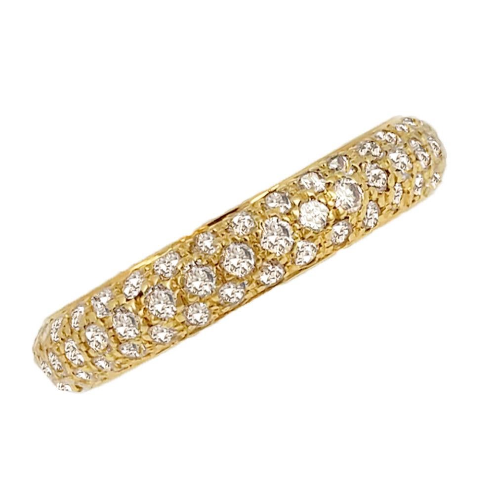 This diamond eternity ring of bombe form features three rows of pave set round-cut diamonds and is expertly crafted in 18 karat yellow gold band. It is signed Cartier, with serial number G76946, with French assay marks for 18 karat gold and maker's