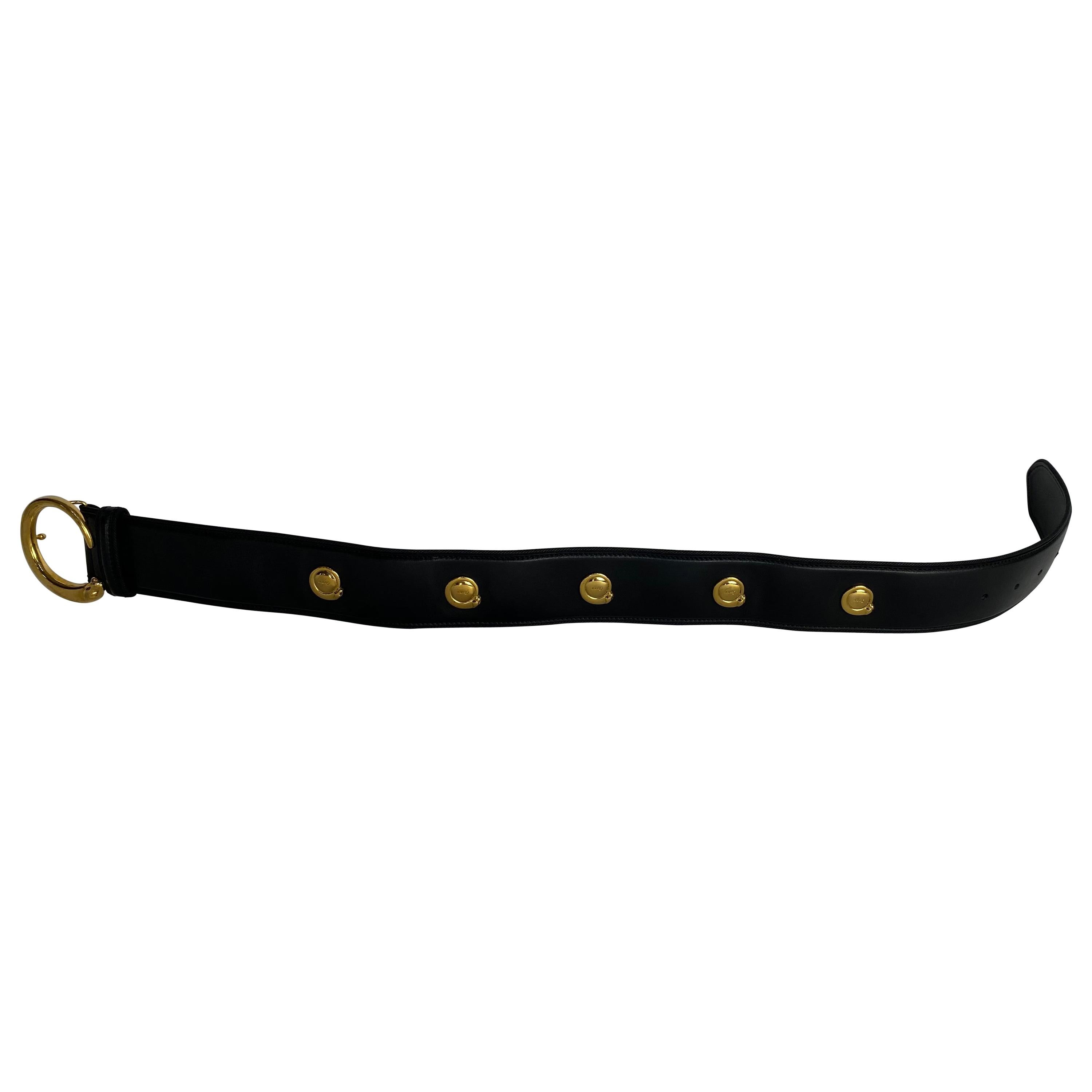 Ein schwarzer Cartier-Gürtel mit goldener Schnalle und 5 kleinen goldenen Jaguarknöpfen, jeder Knopf mit Cartier-Markierung, die goldene Jaguarschnalle ebenfalls mit Cartier 1930-Markierung, Größe klein. Der Gürtel ist außen aus schwarzem Leder und