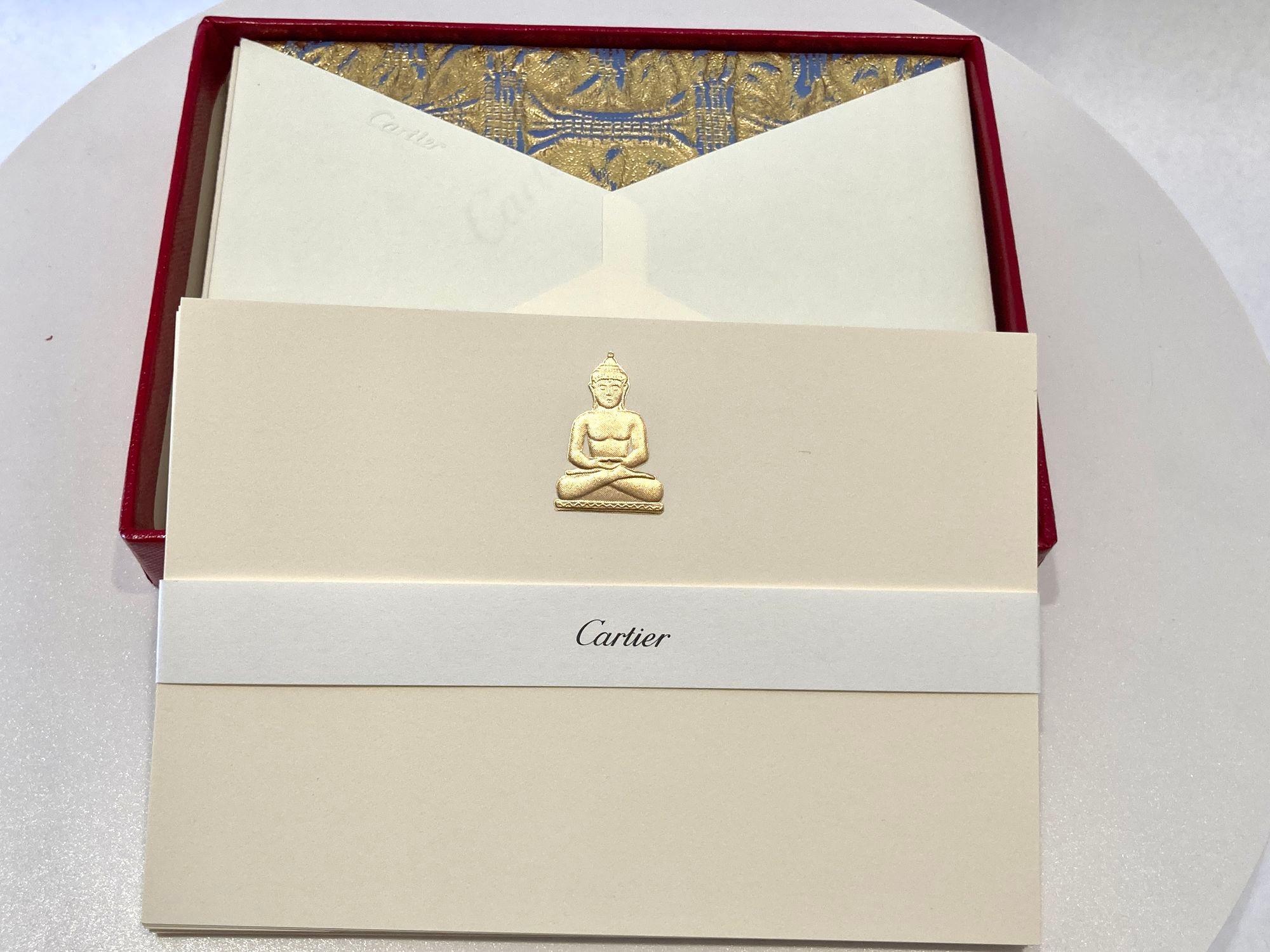 Set di biglietti e buste Cartier con l'iconico ciondolo Buddha seduto in oro Cartier.
Autentico biglietto di cartoleria di lusso Cartier con lettera e busta con l'iconico ciondolo del Buddha seduto in oro.
Accessorio da scrivania in edizione