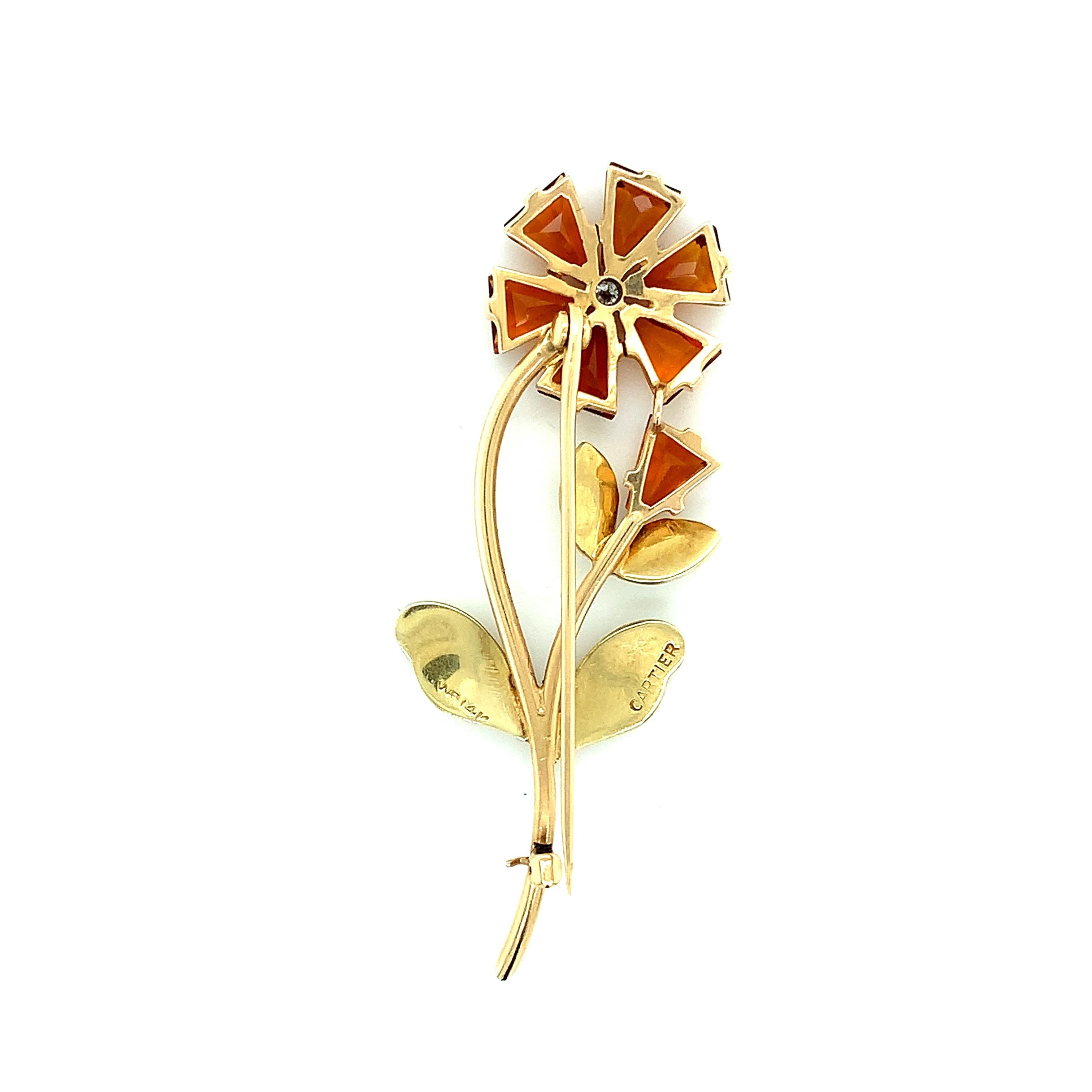 Cartier brooch with a flower motif. The flower's petals are made out of citrine while its stem and leaves are made out of 14 karat yellow gold. There is a single round cut diamond at the center of the flower. Marked: Cartier / 14K. Total weight: 8.3