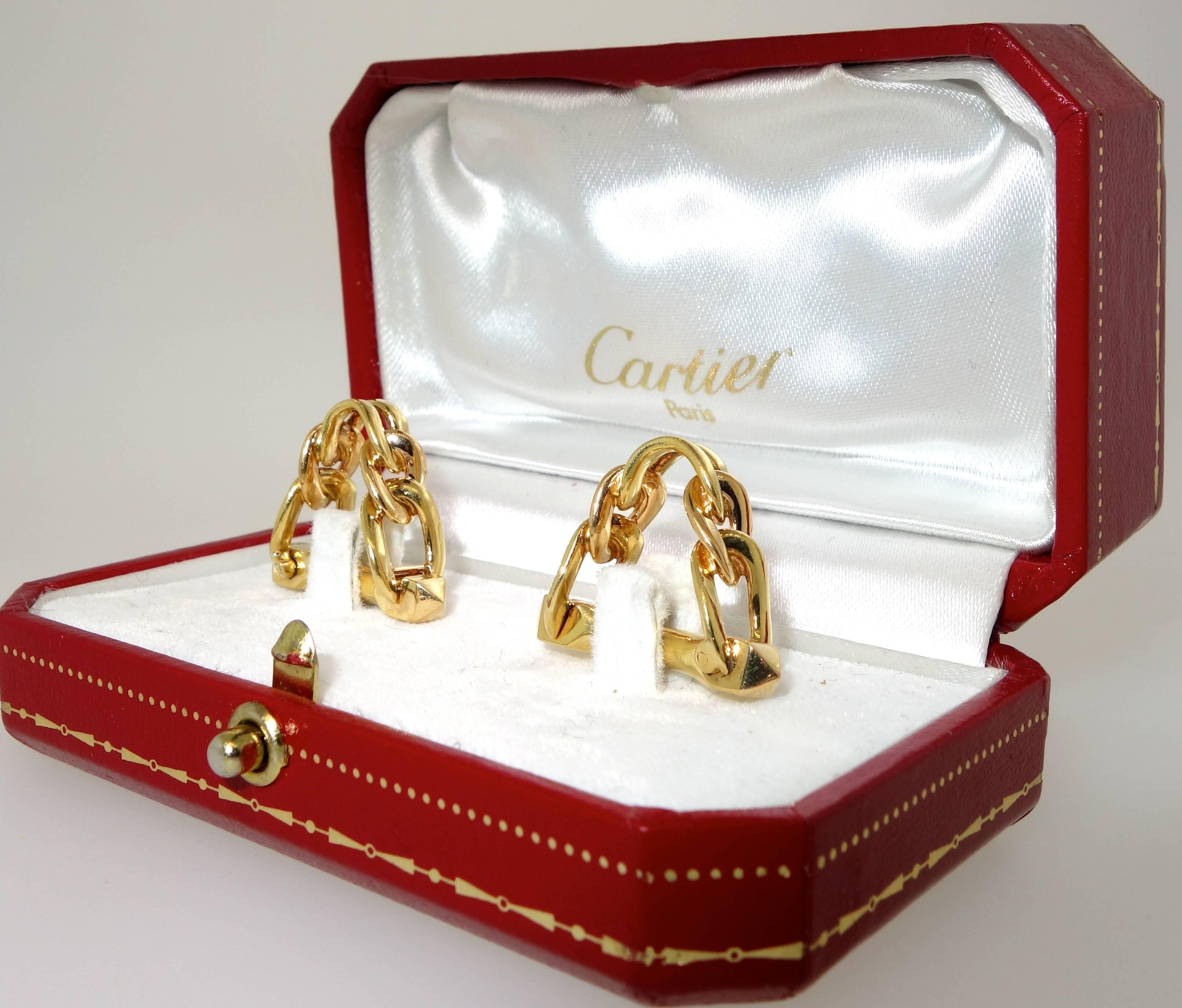 Stirrup motif in 18K yellow gold by the great jewelry House of Cartier.  Signed and numbered with French hallmarks.  The bottom hinges out for easy on and off.