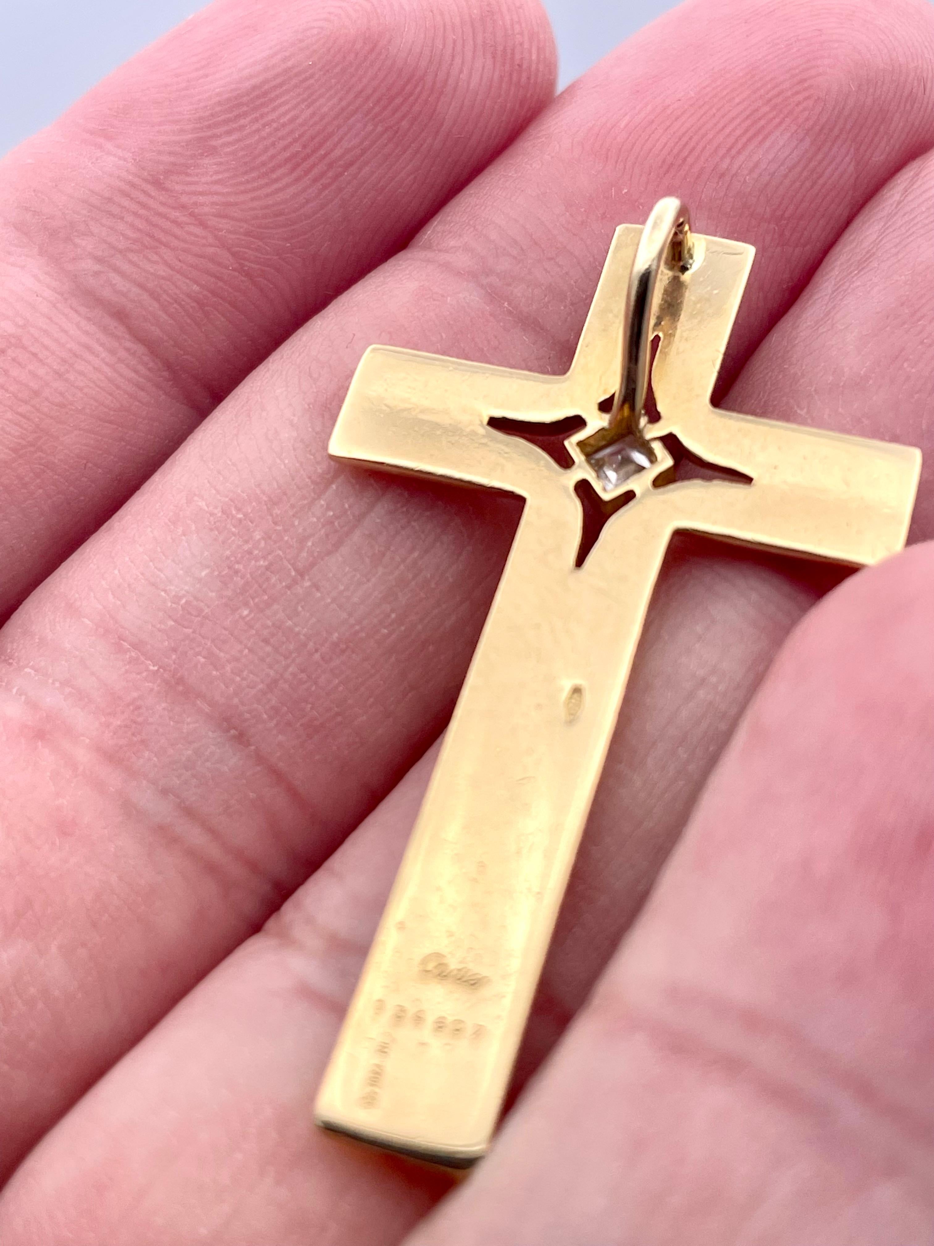 Timeless gold and diamond cross.  Made, signed and numbered by CARTIER.  Solid gauge 18K yellow gold, that is rounded and beveled.   A single square-cut diamond is cut-out in the center.  1 1/2