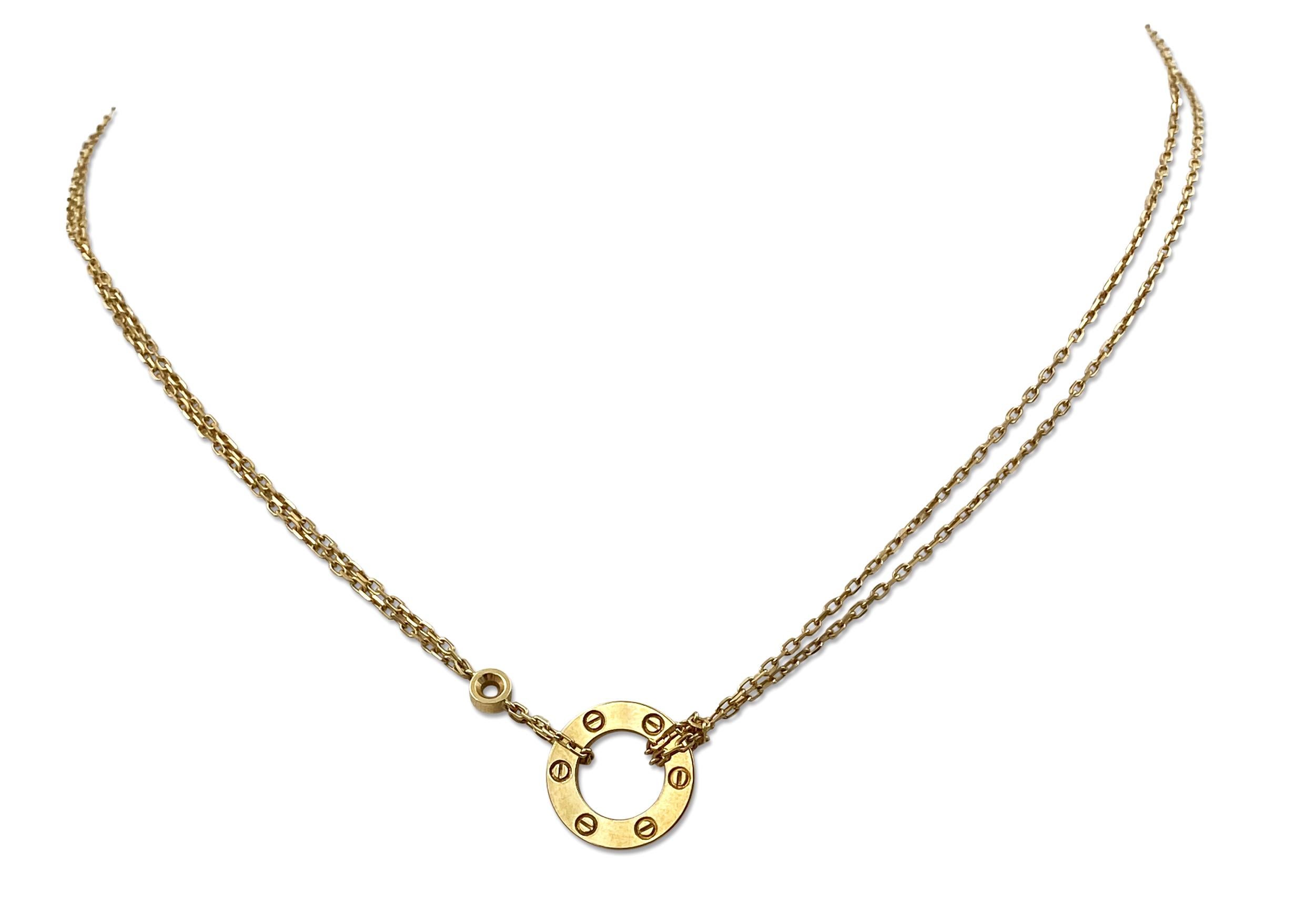 Authentic chain and ring charm necklace from the Cartier Love collection. Made in 18 karat yellow gold and double strand oval link chain with a half inch round ring and screw top motifs set with two round brilliant cut diamonds of approximately 0.30