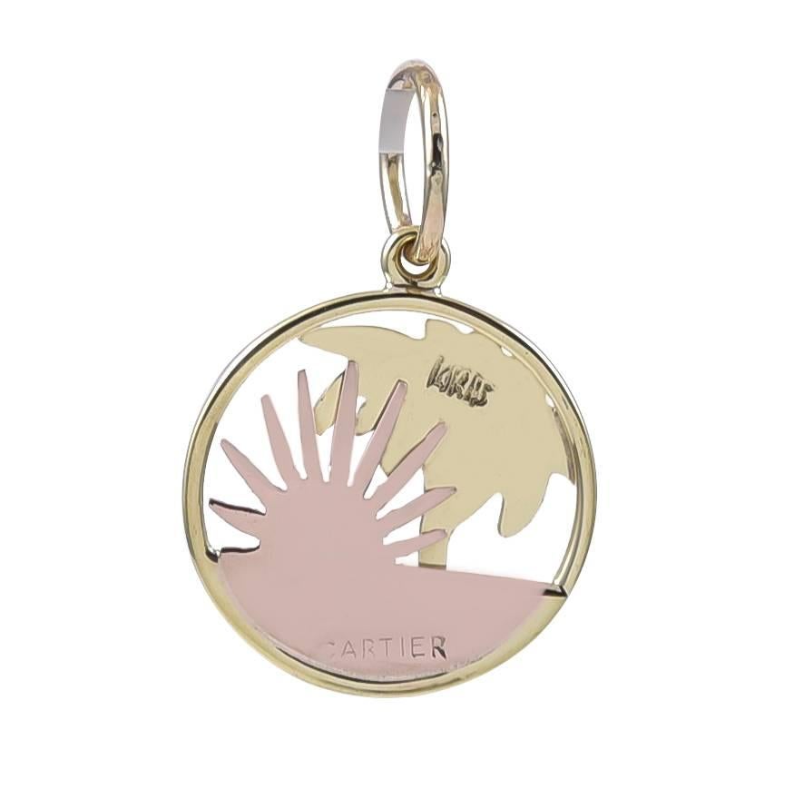 14K yellow and rose gold charm.  Made and signed by CARTIER.  Depicting a figural palm tree, the setting sun and the beach.  2/3