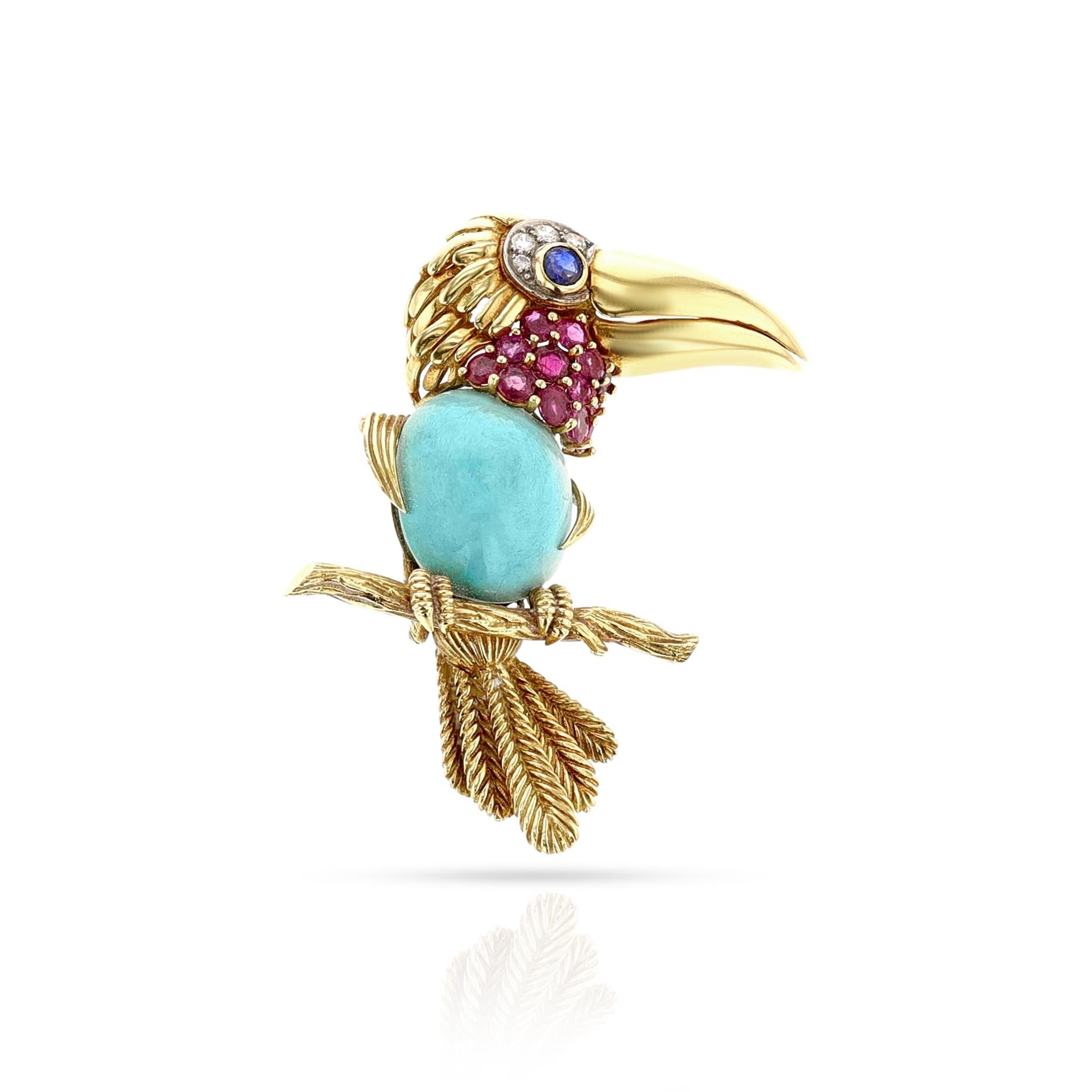 A Cartier Gold, Platinum, Turquoise, Ruby, Sapphire and Diamond Toucan Brooch, crafted by skilled artisans in France with 18k gold and adorned with a beautiful oval cabochon turquoise measuring 18 x 16 MM. The toucan's eye is a stunning sapphire