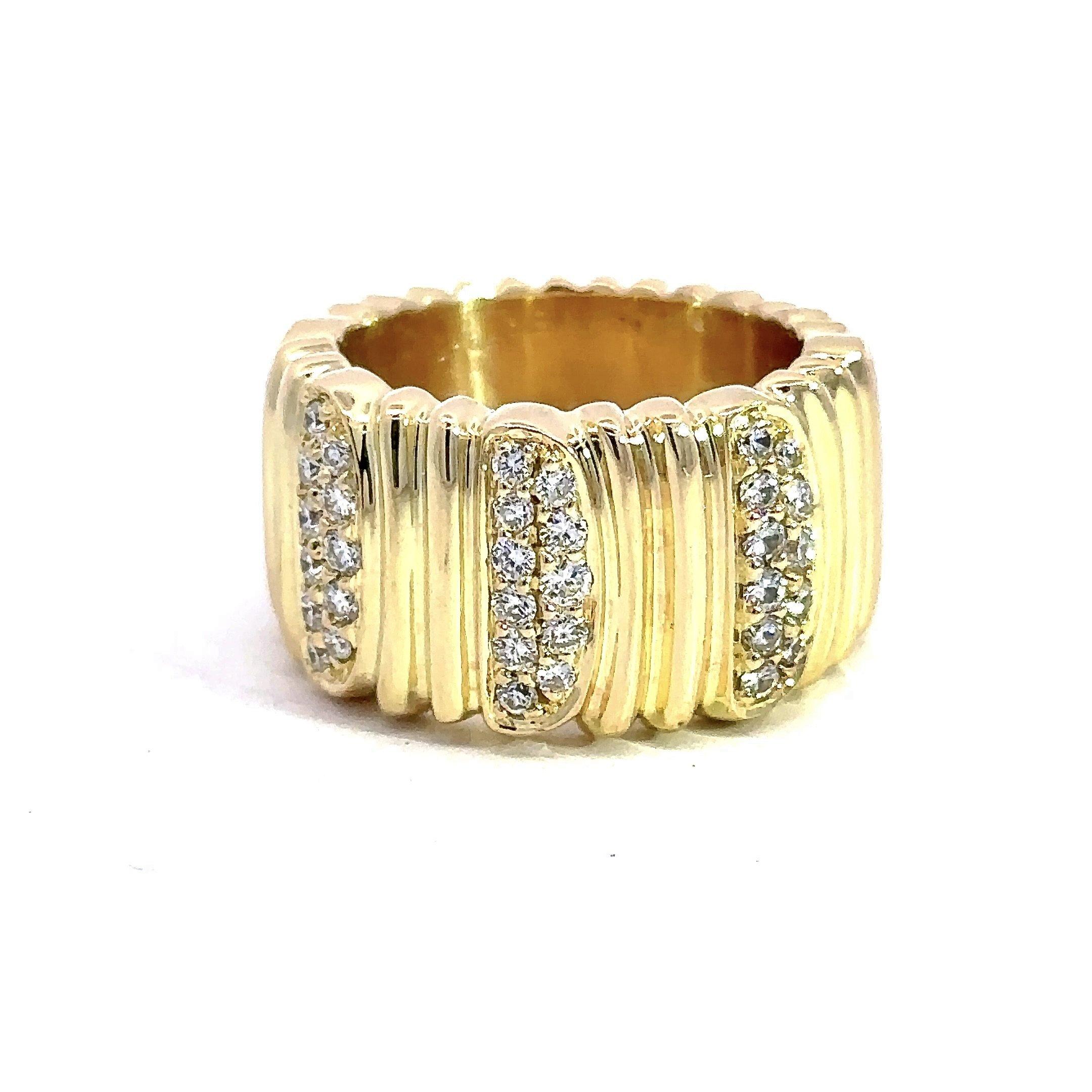 This Cartier “Golden Helmet” textured band is crafted in 18KT yellow gold with an embellishment of sparkling round diamonds, F Color VS Clarity, which add dimension and flash to this signature Cartier piece. It is stamped Cartier 1993. The ring is a