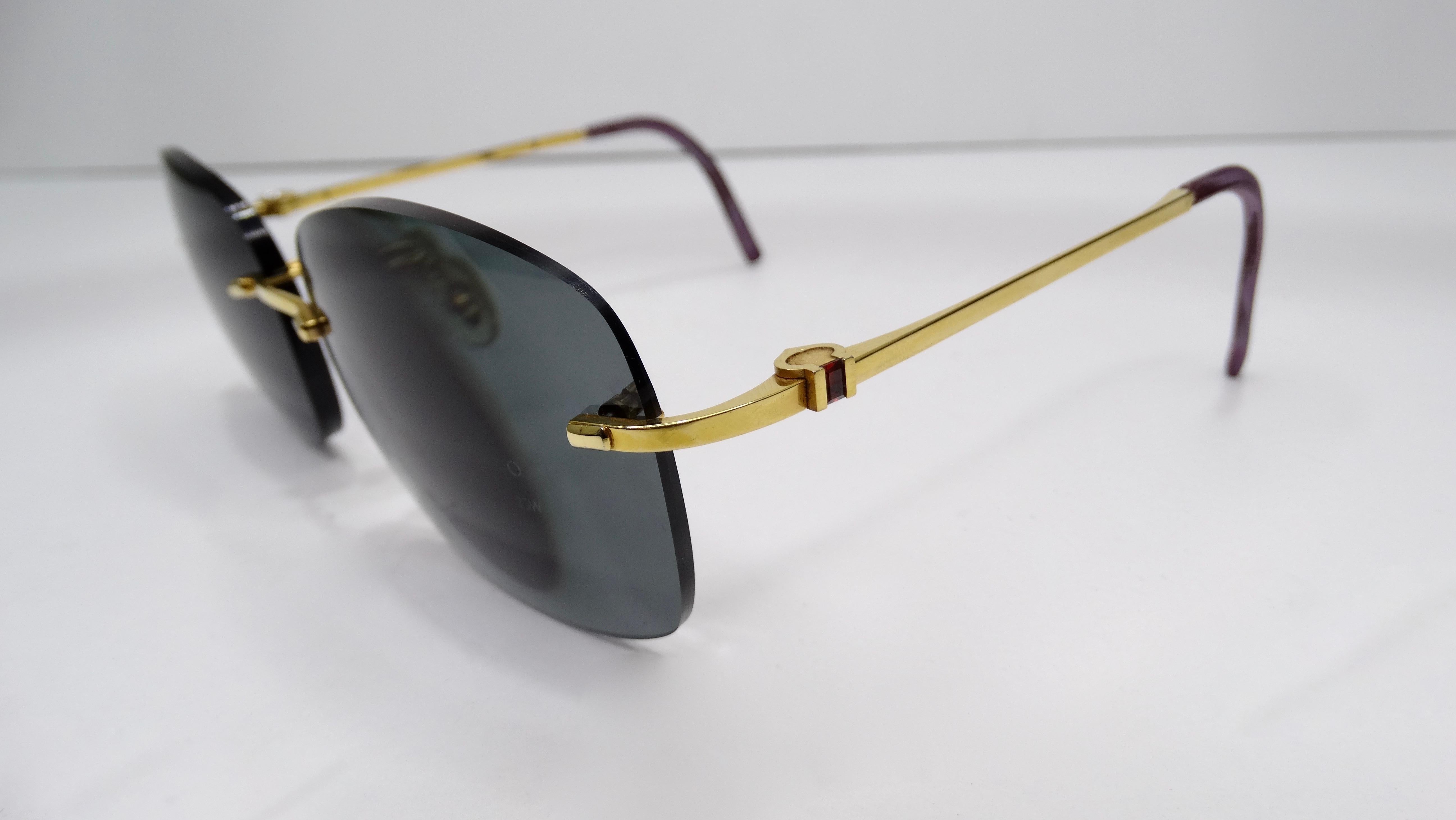 A favorite of both jewelry and fashion lovers, Cartier is always a classic! Circa 1980s, these rimless sunglasses feature an 18k gold plated frame with a small red granite on each arm. Cartier stamping throughout. The lenses in these sunglasses are