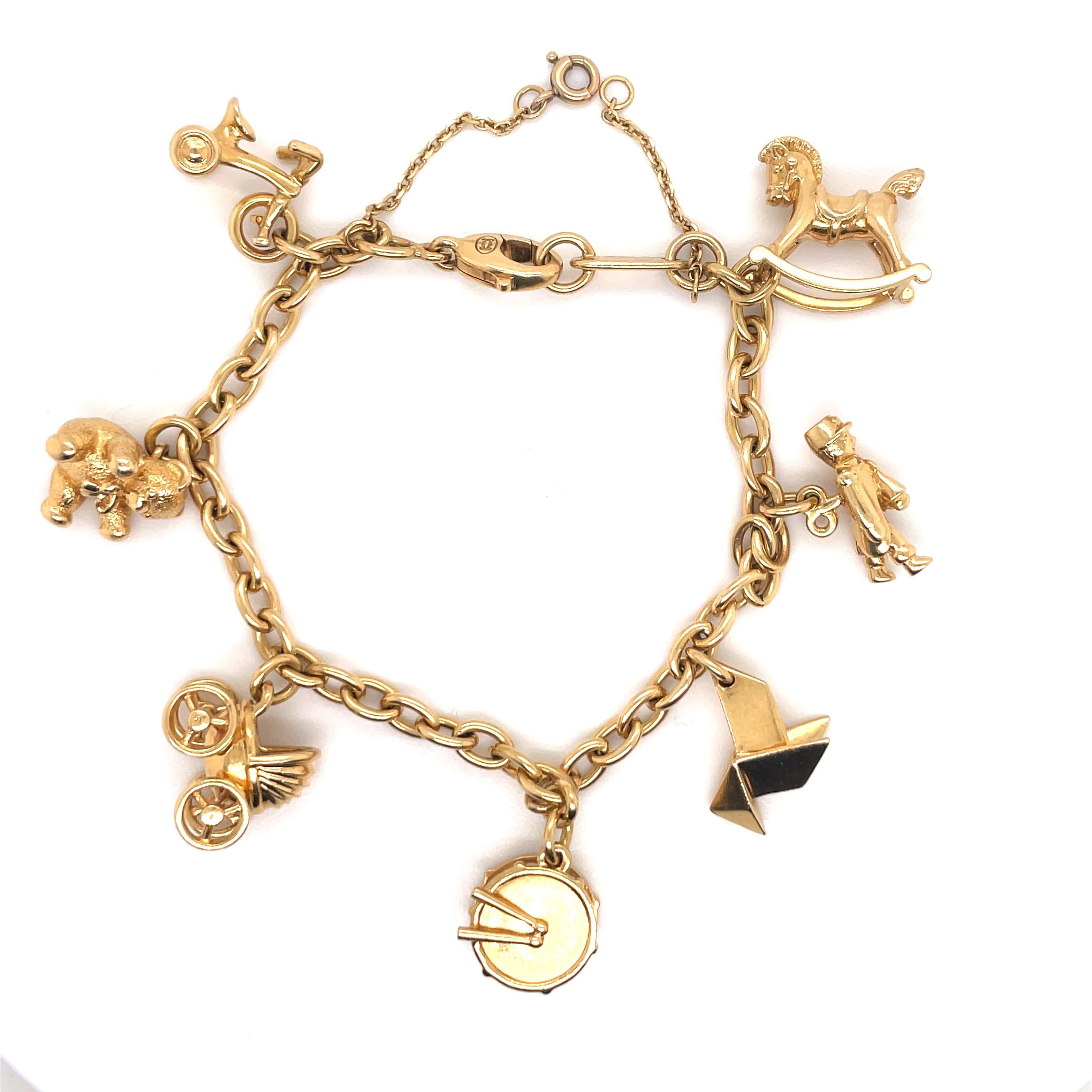 Cartier link bracelet featuring 7 charms crafted in 18 Karat yellow gold. 
Lists of Charms:
Bicycle
Teddy Bear
Baby Carriage
Drums
Origami 
Military Man
Rocking Horse 