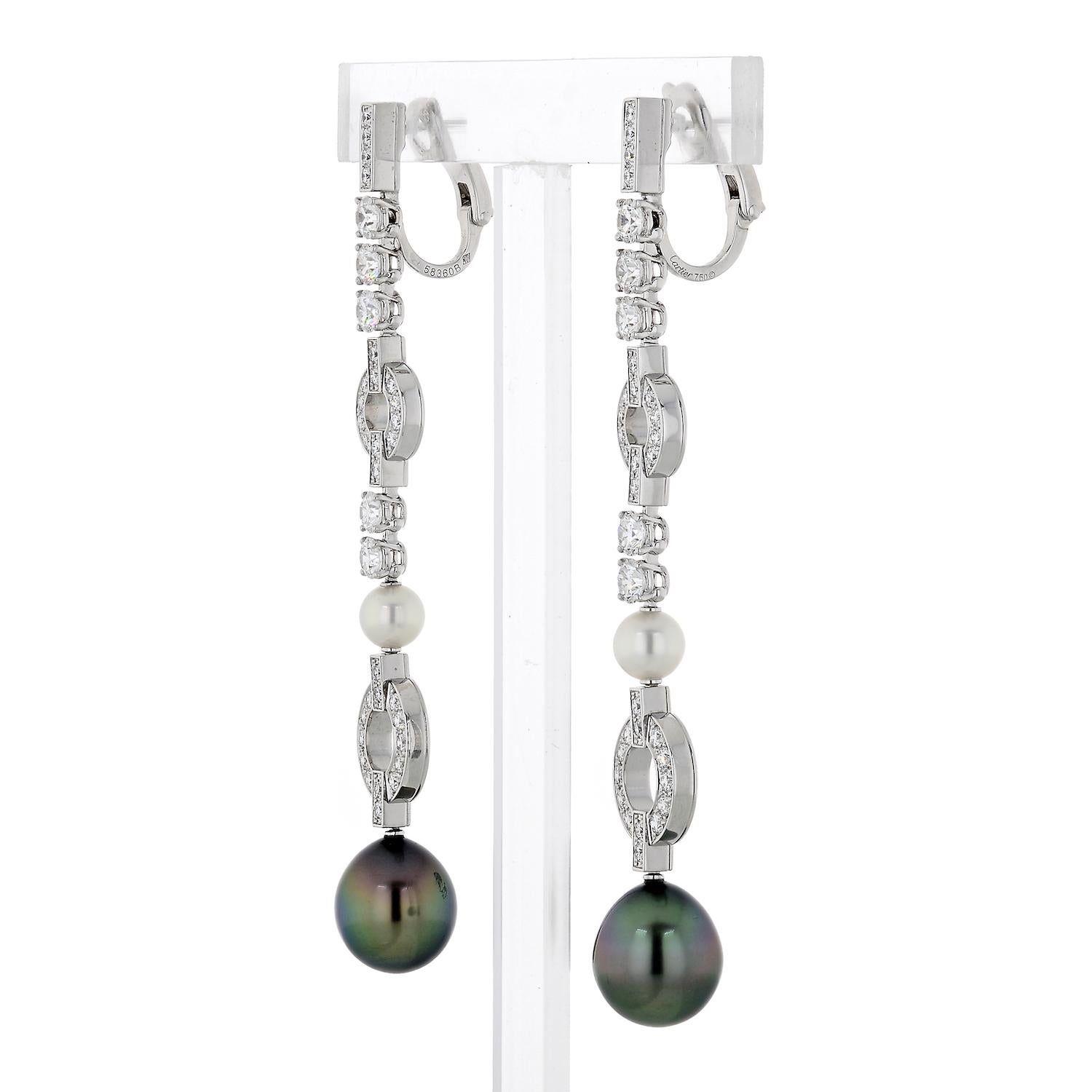 A striking pair of Cartier diamond drop earrings featuring black and white pearls nestled in 18k White Gold that is decorated in approximately 4.18 carats of diamonds. These Cartier diamond drop earrings are an amazing 3.25 inches in length and are