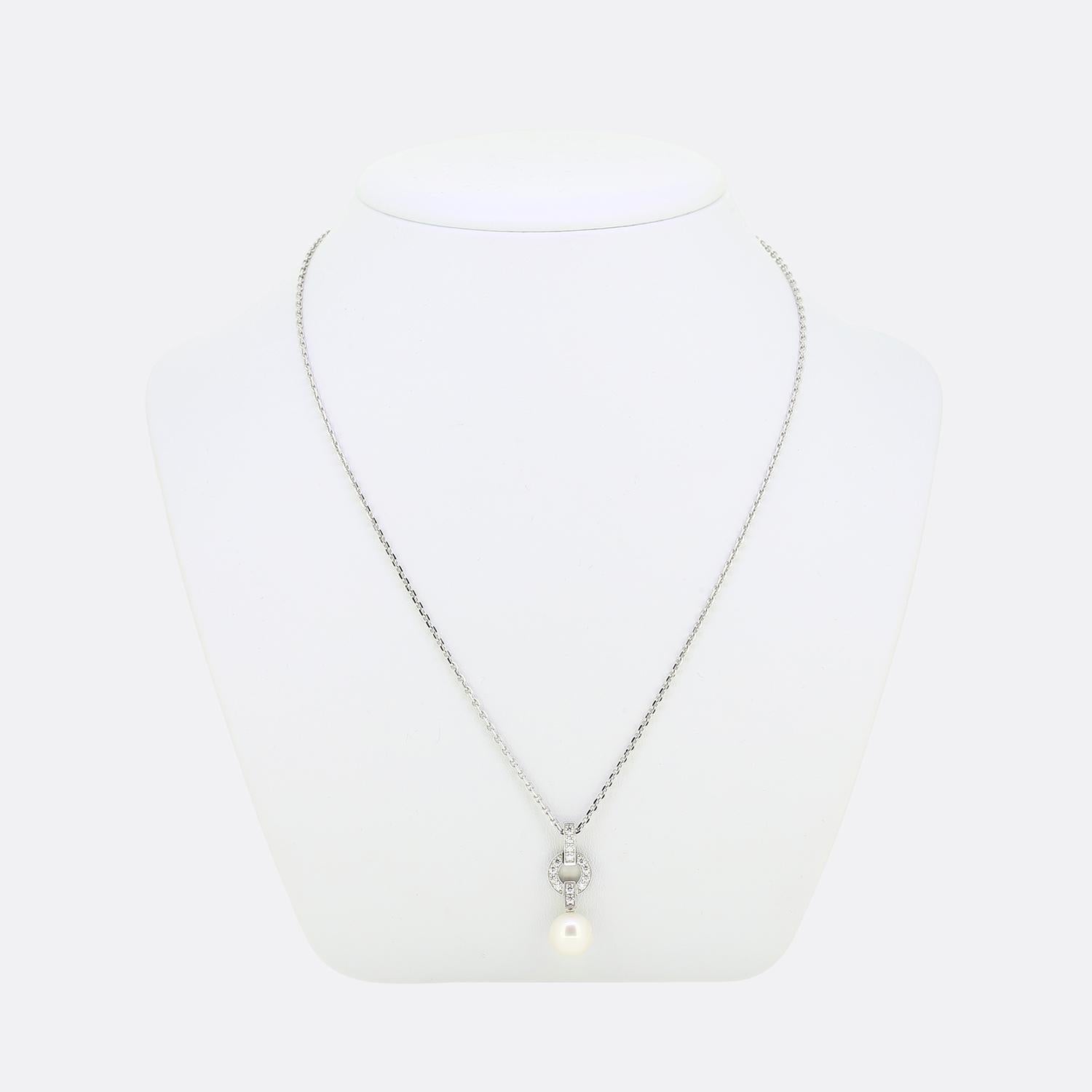 Voici un charmant collier de la maison de joaillerie de renommée mondiale Cartier. Cette pièce élégante présente un pendentif ouvert au design minimaliste, rempli de diamants exquis et terminé par une grosse perle arrondie en dessous.