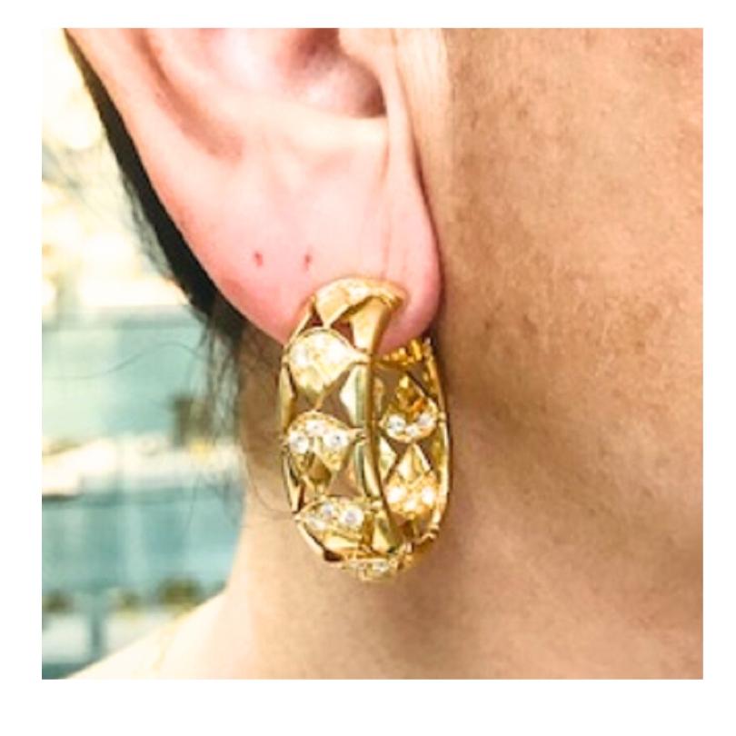 A spectacular pair of Cartier hoop earrings with diamonds, crafted of 18k gold.
The earrings feature a quilted pattern with diamond accents nestled within each triangular shaped section. The design plays with both texture and structure and gives the