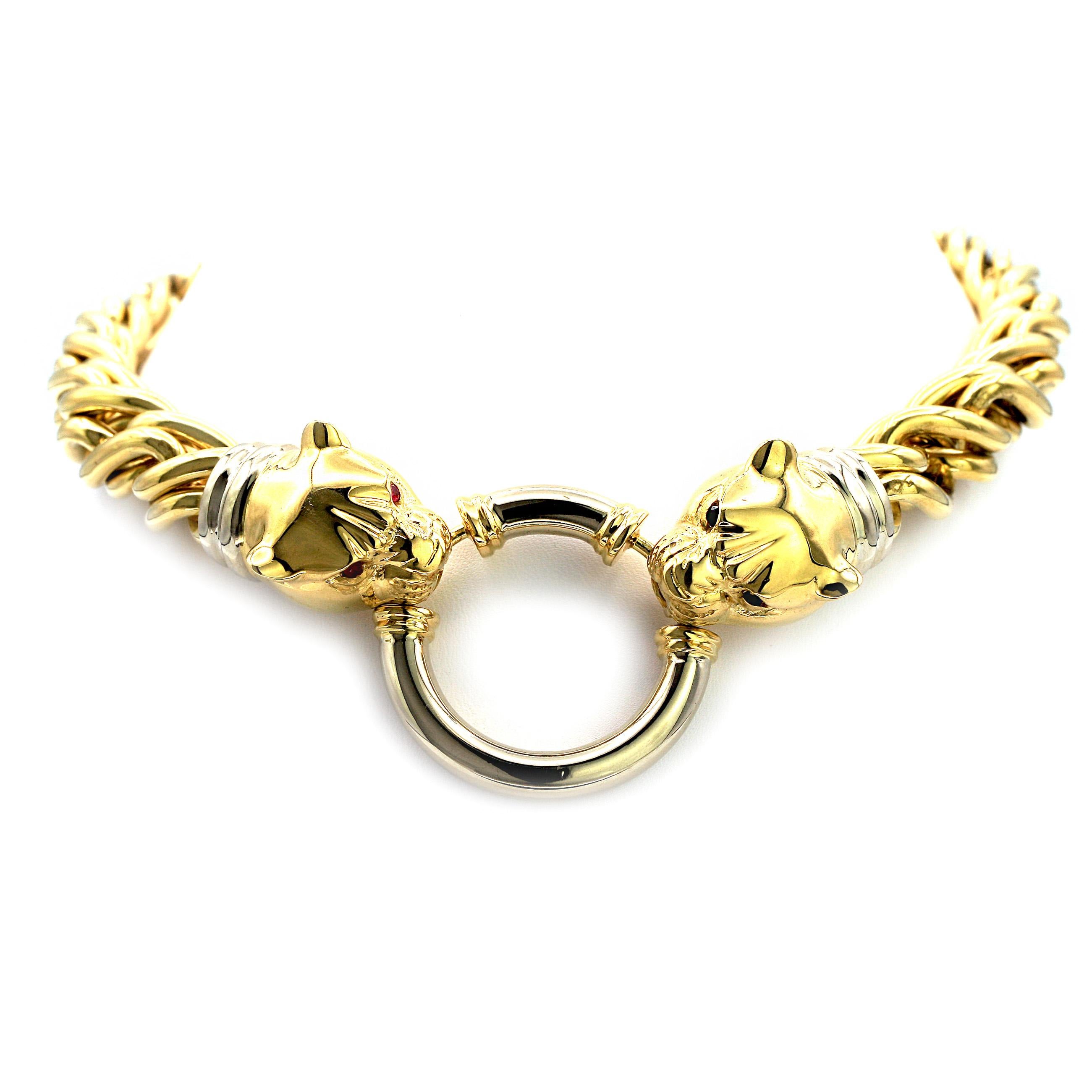 This inspired necklace features two tiger heads latching onto a ring in the center. The diameter of the link of the necklace gradually gets smaller towards the back.  
The two tigers have eyes; one is filled with rubies, the other with blue