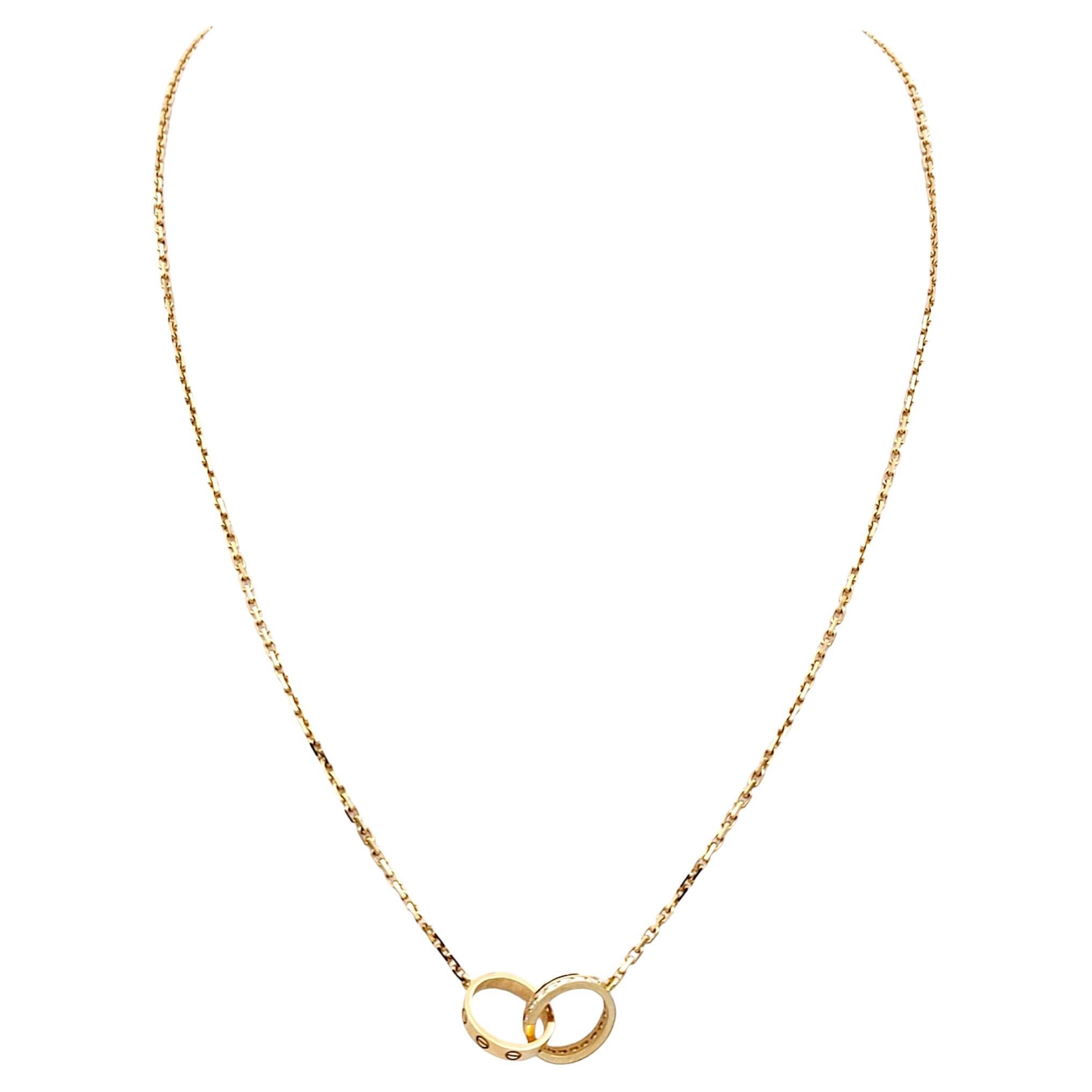 This Cartier LOVE Collection pendant necklace is a masterpiece of timeless elegance and sophistication. Crafted with meticulous attention to detail, this designer necklace features two interlocking rings that symbolize enduring love and unity.

The