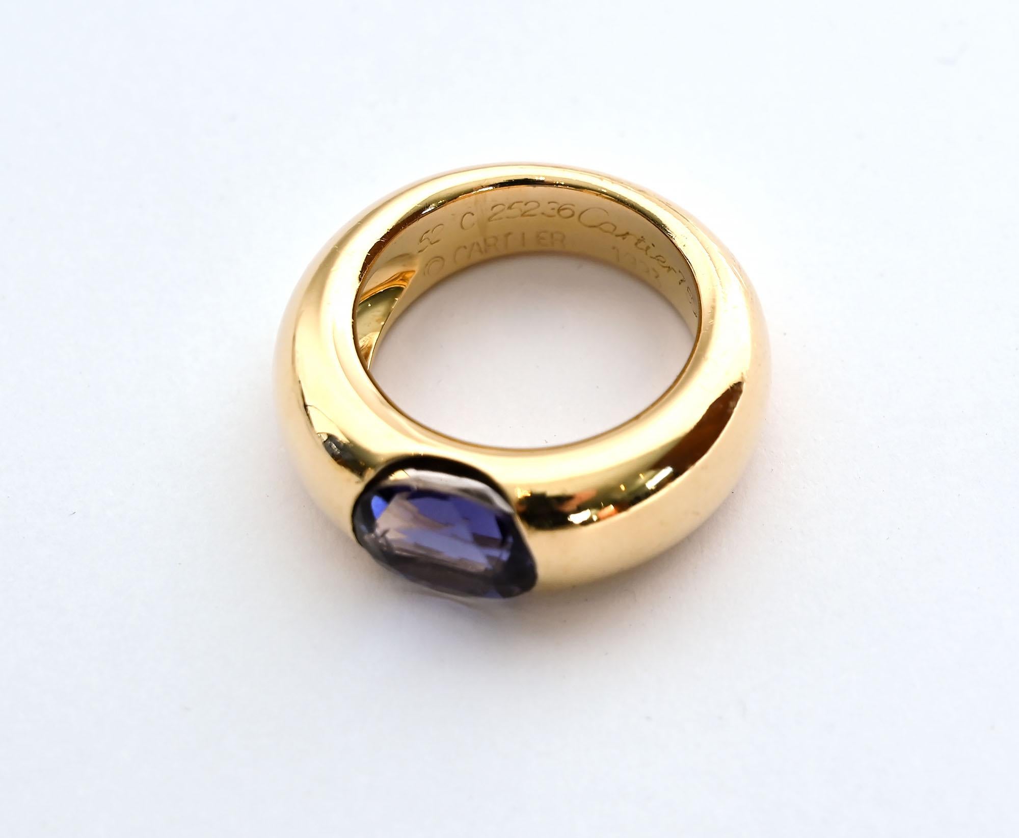 Cartier 18 karat gold ring with a central iolite stone of a beautiful shade of blue. The ring is 3/8