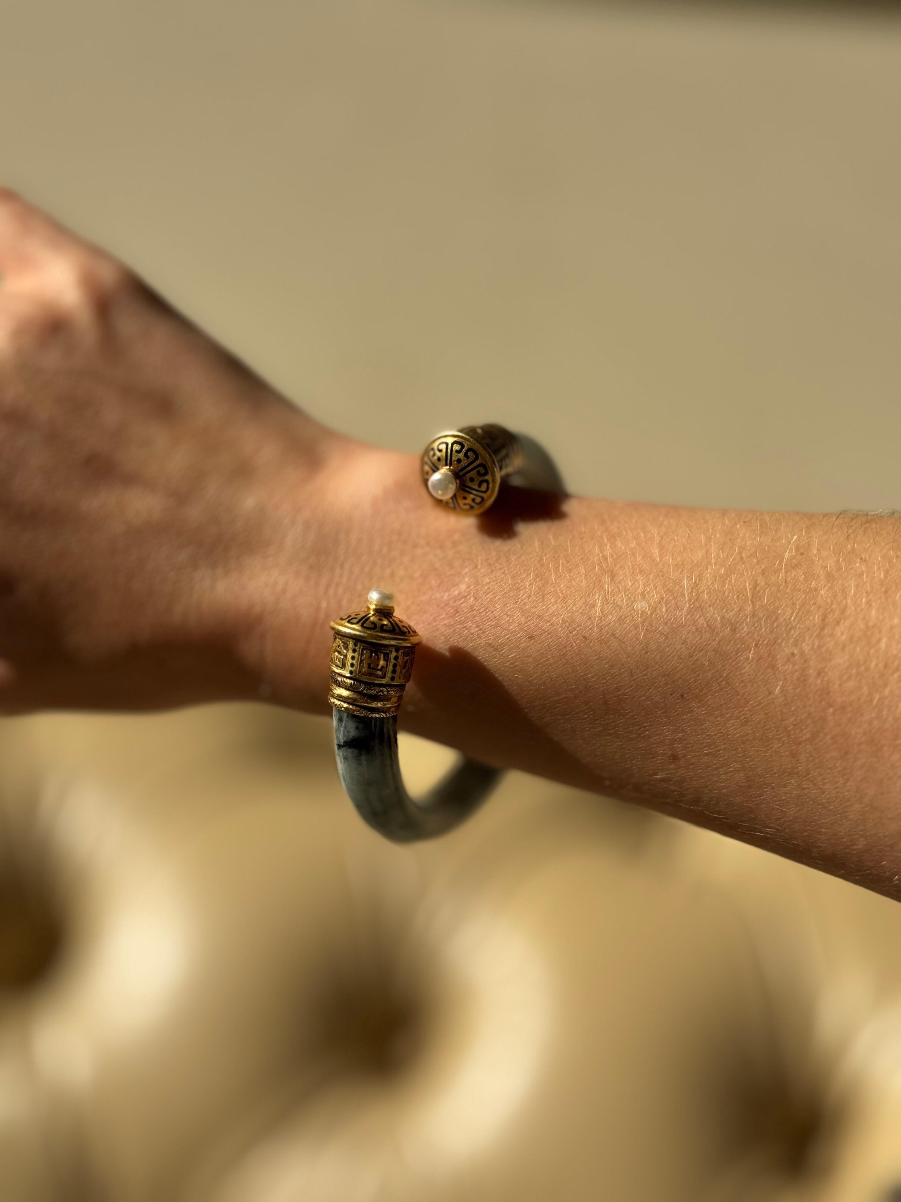 Bracelet manchette vintage en or 18k de Cartier, avec jade et deux perles.

Le bracelet a un diamètre intérieur de 2,5