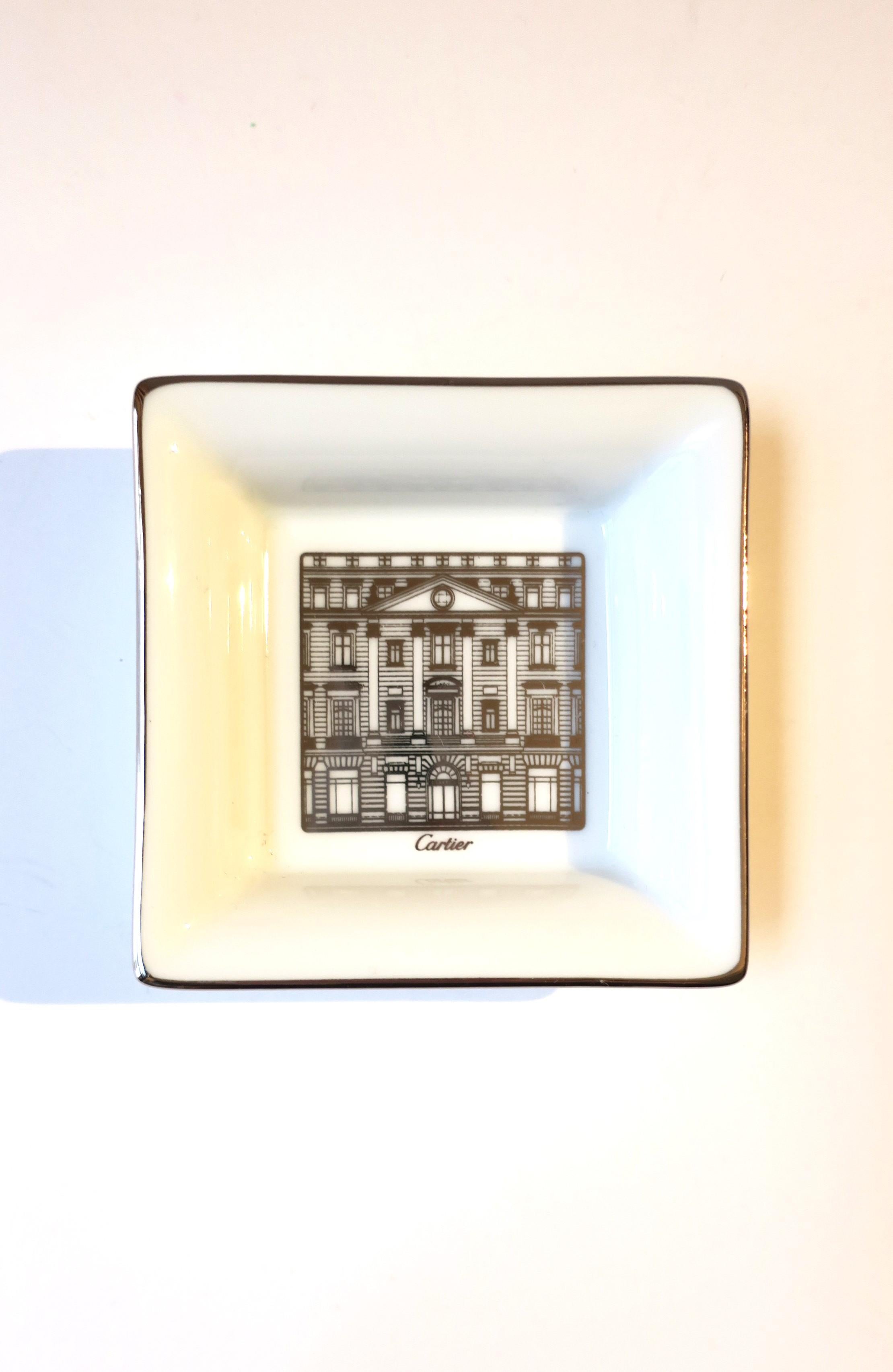 A beautiful piece of fine French porcelain from luxury Maison Cartier, circa late-20th century, France. This small jewelry dish has a silver edge and a fine depiction of the Cartier Mansion, 'Cartier' at bottom of. As described on side of iconic red