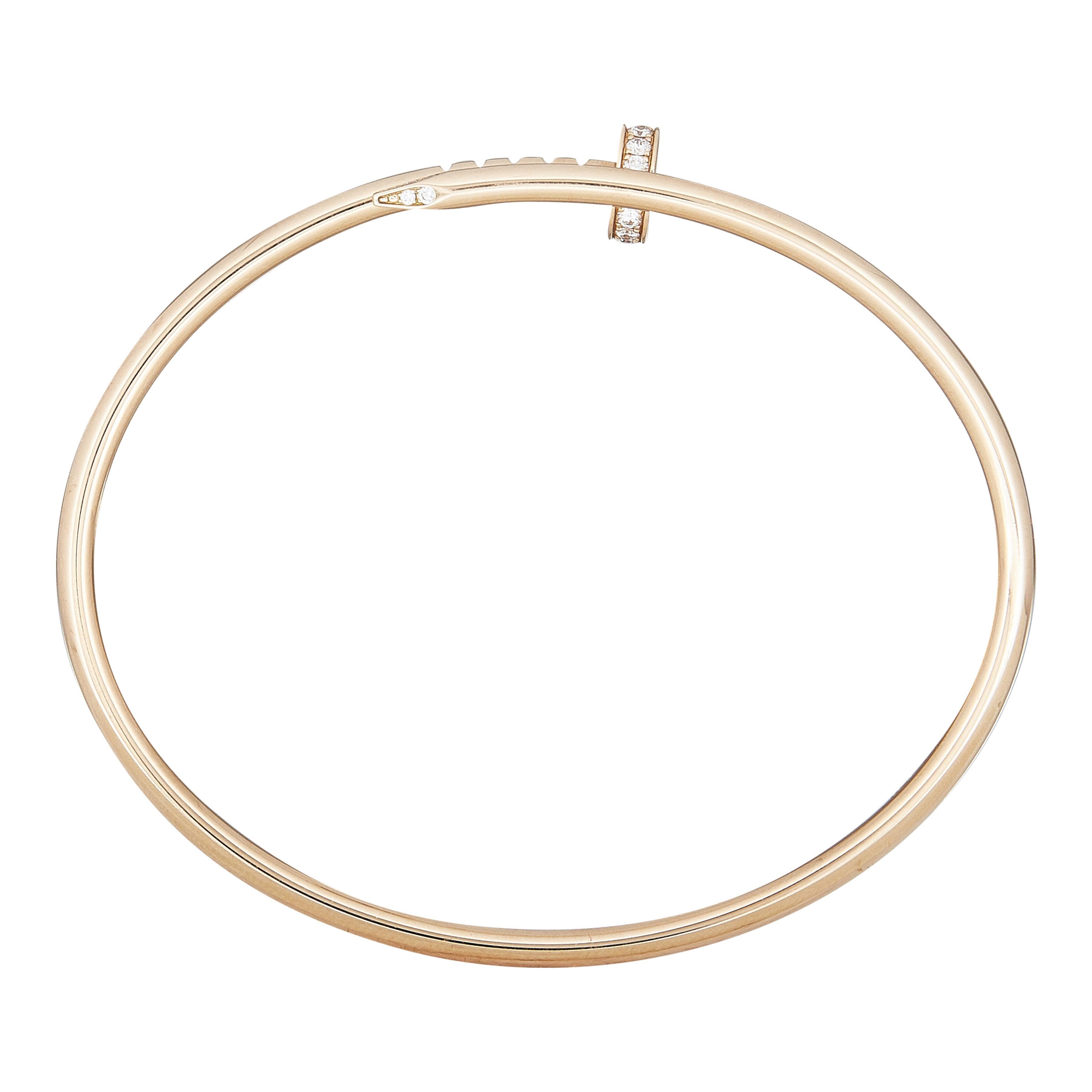 Das Armband:
Ein Cartier Juste un Clou Armreif. Dieses kleine Modell ist aus achtzehn Karat Roségold gefertigt und mit runden Diamanten im Brillantschliff besetzt.

Das Armband ist in ausgezeichnetem Zustand, mit nur ein paar kleinen Kratzern, die