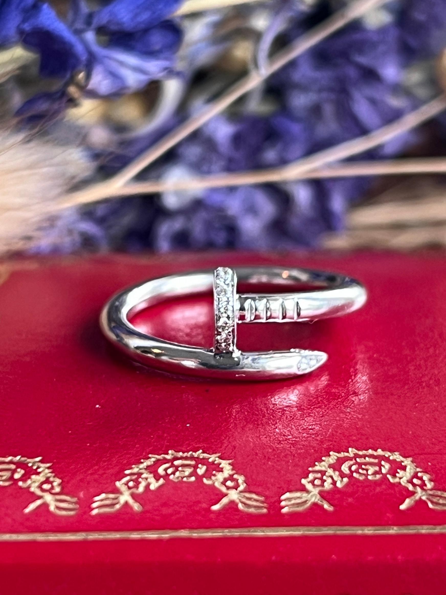 Contemporary Cartier Juste Un Clou Diamond and 18 karat white gold ring. This ring features Cartier's iconic curved nail design accented by 22 round brilliant diamonds, approximately 0.13 total carat weight, with E color and VS2 clarity. This ring