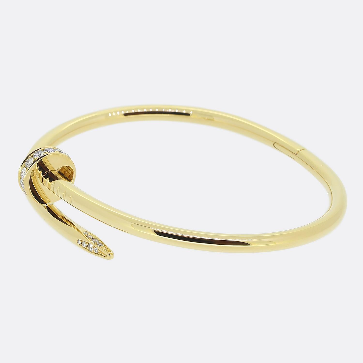 Here we have an 18ct yellow gold bracelet from the world renowned luxury jewellery house of Cartier. This piece forms part of their iconic Juste un Clou collection and showcases a wrap around nail design with a diamond set head and tip. This is the