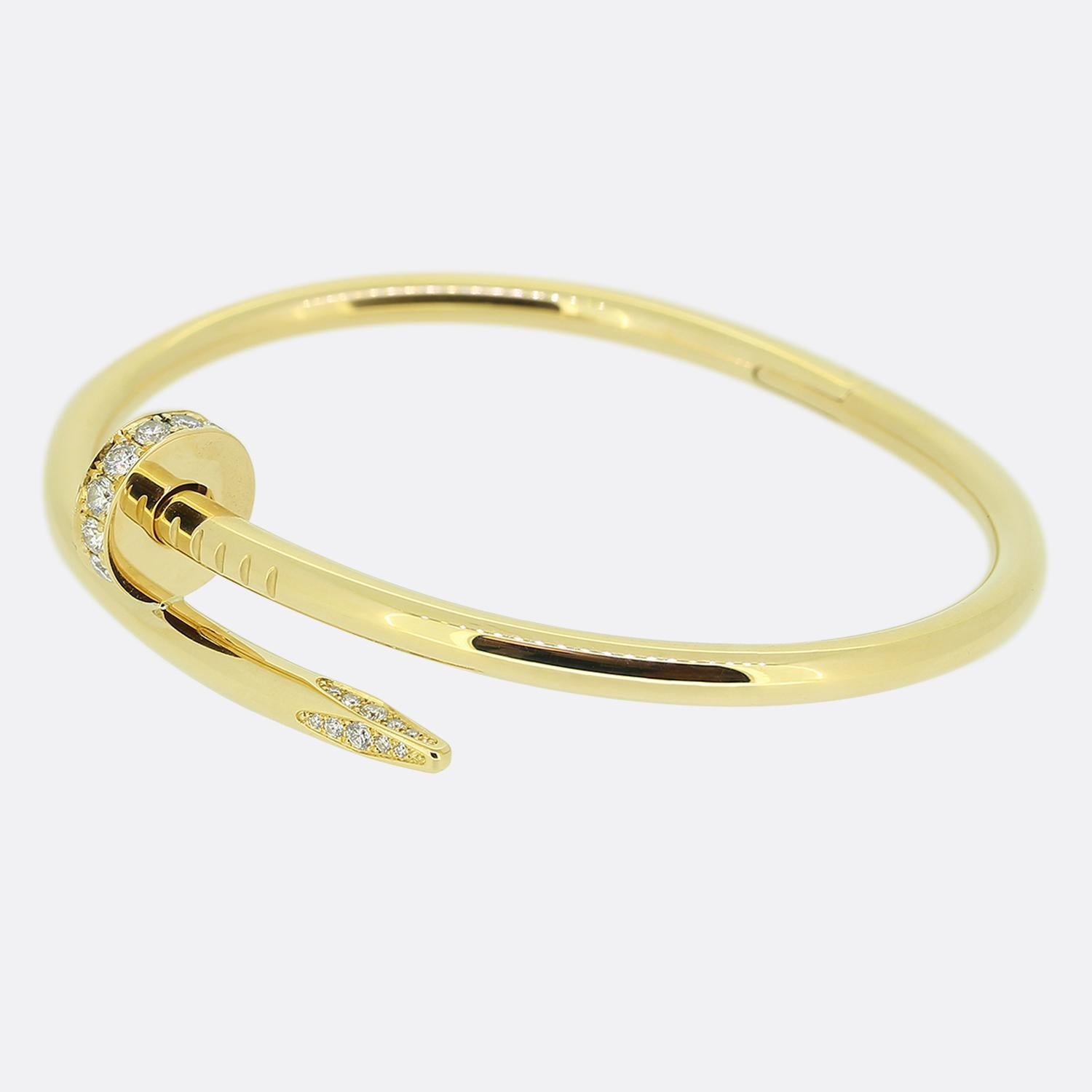 Here we have an 18ct yellow gold bracelet from the world renowned luxury jewellery house of Cartier. This piece forms part of their iconic Juste un Clou collection and showcases a wrap around nail design with a diamond set head and tip. This is the