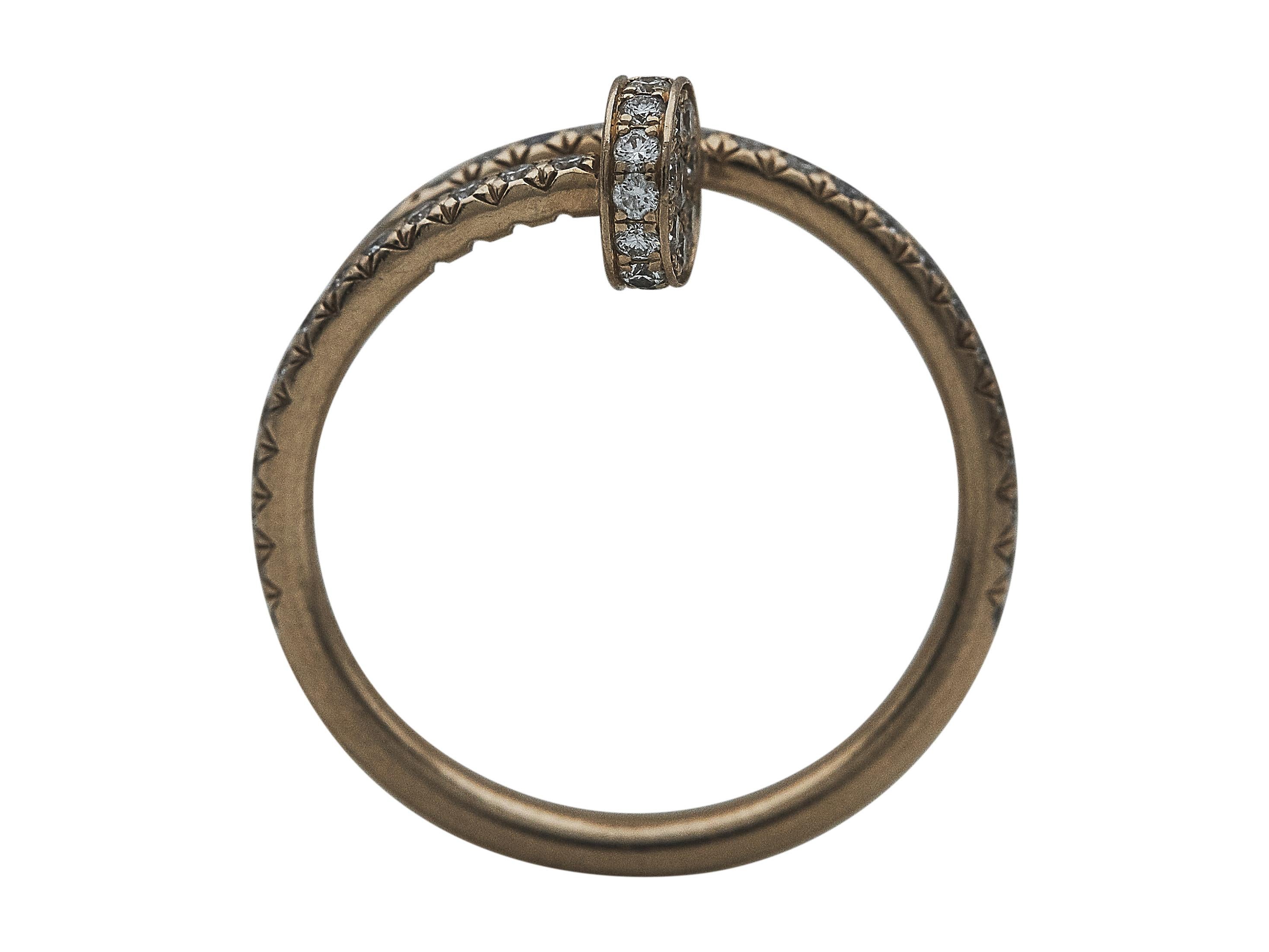 Der Ring: Ein Ring von Cartier Juste un Clou. Dieses kleine Modell besteht aus achtzehn Karat Roségold und ist mit runden Diamanten im Brillantschliff besetzt. Es ist eine Größe 52.

Begleitet von
