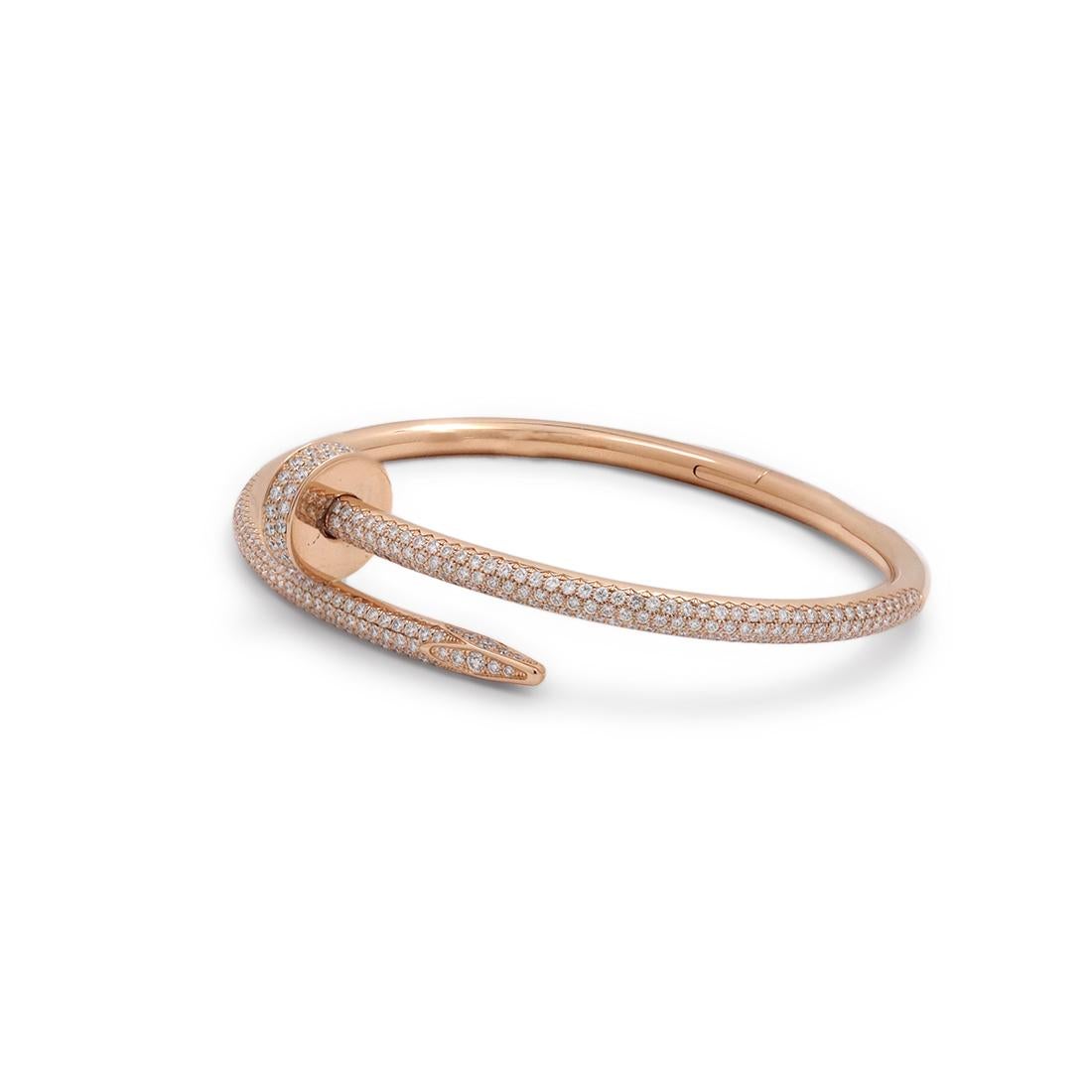 Designed as a 'just a nail', this authentic Cartier 'Juste un Clou' bracelet is an innovative twist on a familiar and ordinary object. The bracelet is set with high-quality round brilliant cut diamonds (E-F color, VS clarity) weighing an estimated