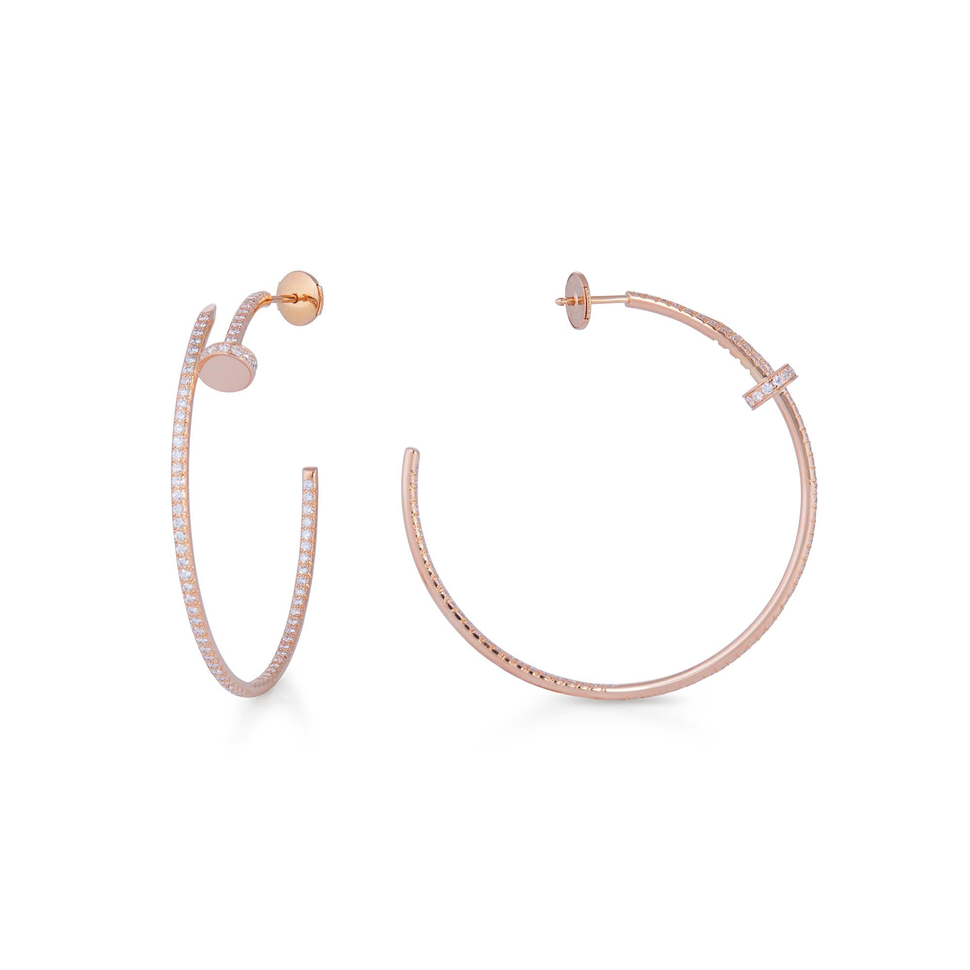 Authentic Cartier Juste Un Clou earrings crafted in 18 karat rose gold features the iconic Cartier nail motif taking the shape of hoop earrings. The earrings are set with 176 round brilliant cut diamonds for an estimated 1.25 total carat weight.