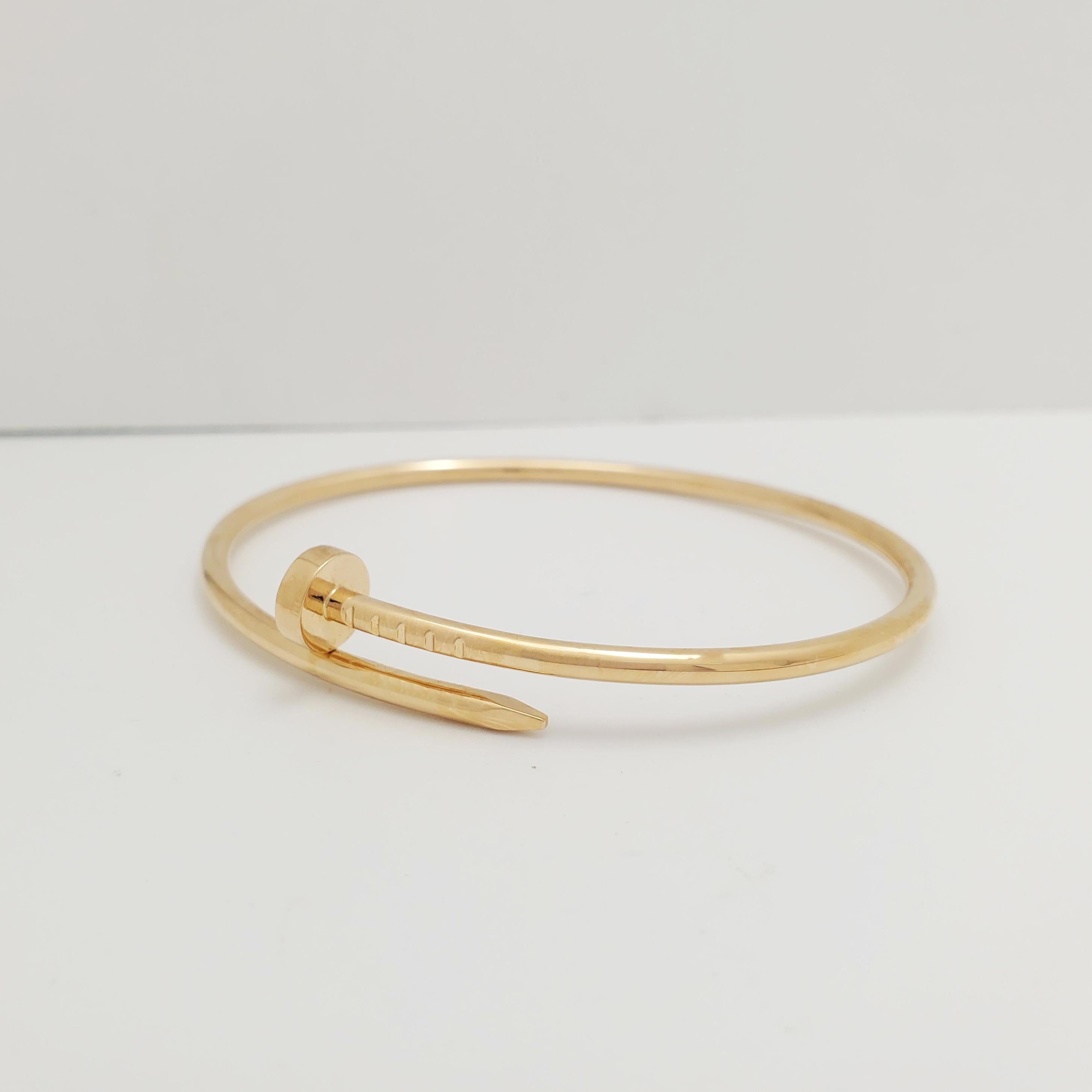 Designed as a 'just a nail', this authentic Cartier 'Juste un Clou' bracelet is an innovative twist on a familiar and ordinary object. Signed Cartier, 17, Au750, with serial number. Presented with the original Cartier box and papers. CIRCA