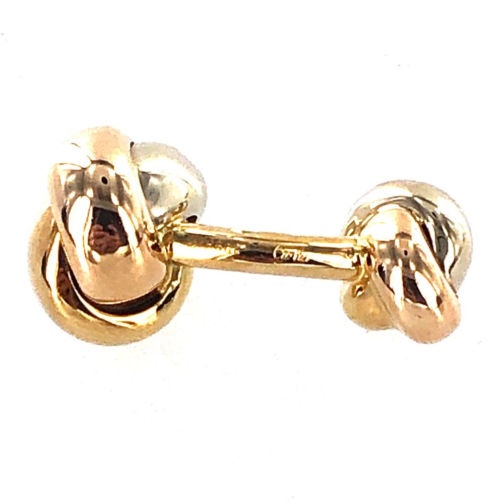1990's Cartier Knot Cufflink and Stud set in 18 karat tricolor gold. The set includes 4 studs, 2 cufflinks, Cartier box, and papers. The cufflinks and studs are signed numbered and hallmarked. 