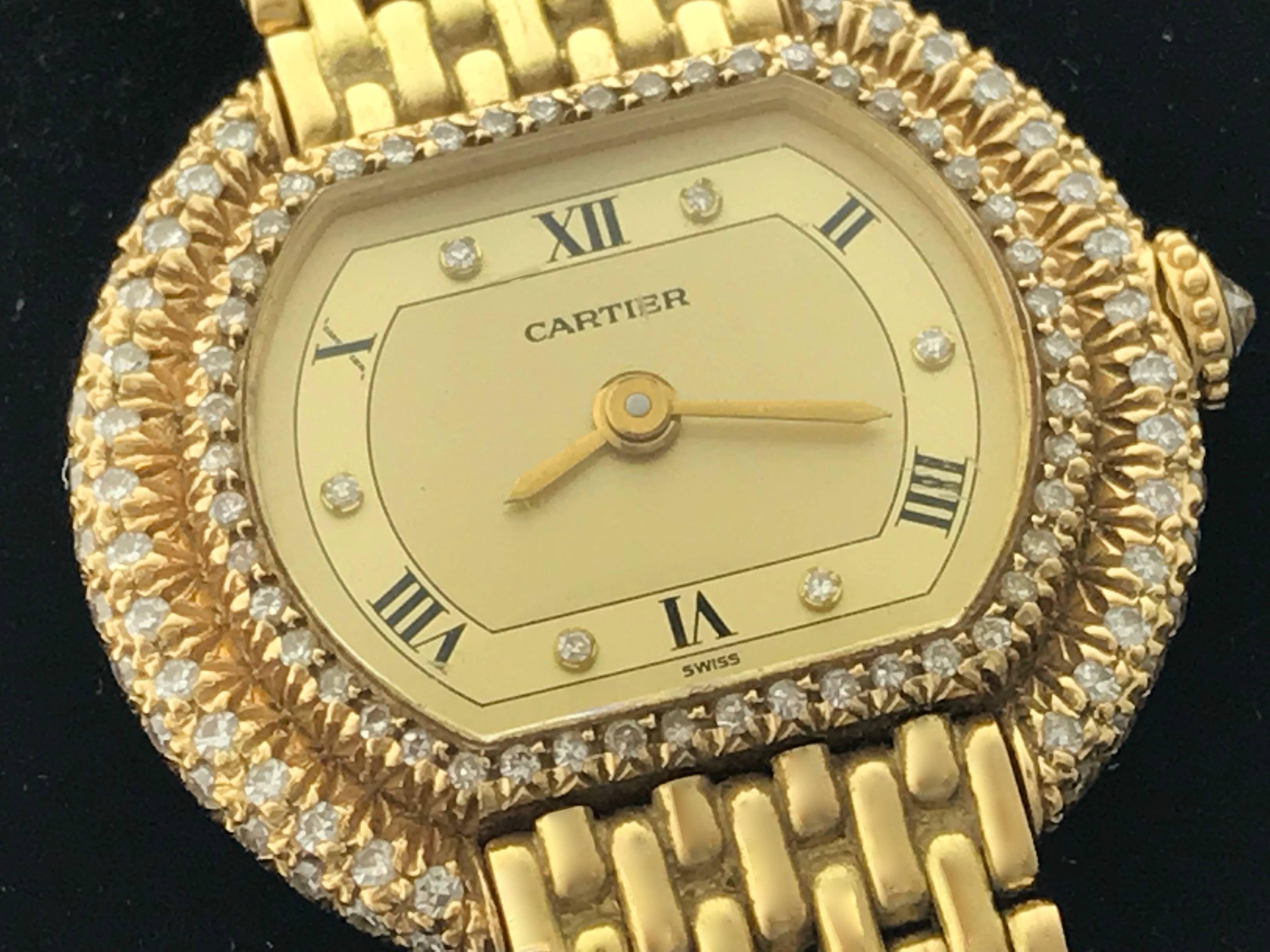 Cartier Pre Owned Ladies Manual Wind wrist watch. Gold Dial with black Roman numerals and Diamond hour markers. 18k Yellow Gold case with Cartier Two-Row Diamond bezel and Diamond cabochon winding/setting crown (24x24mm). 18k Yellow Gold Cartier