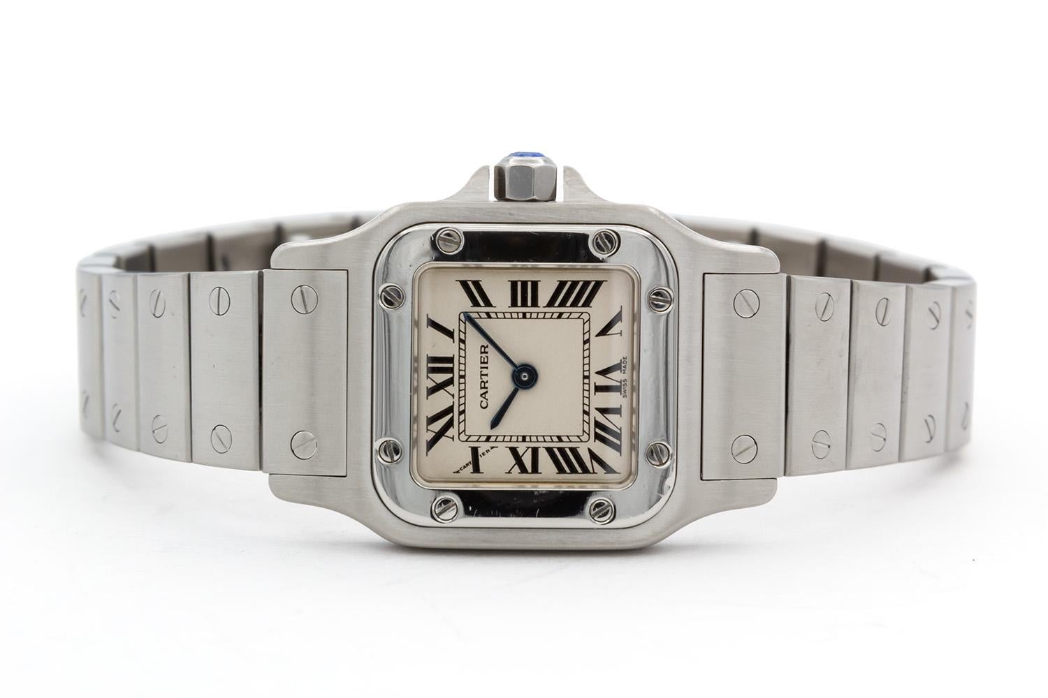 We are pleased to offer this Cartier Ladies Small Santos Galbee Watch with Original Box & Papers. This timeless ladies watch features a 24mm x 24mm stainless steel case, stainless steel bezel, cream/ivory color Roman dial with blue hands, stainless