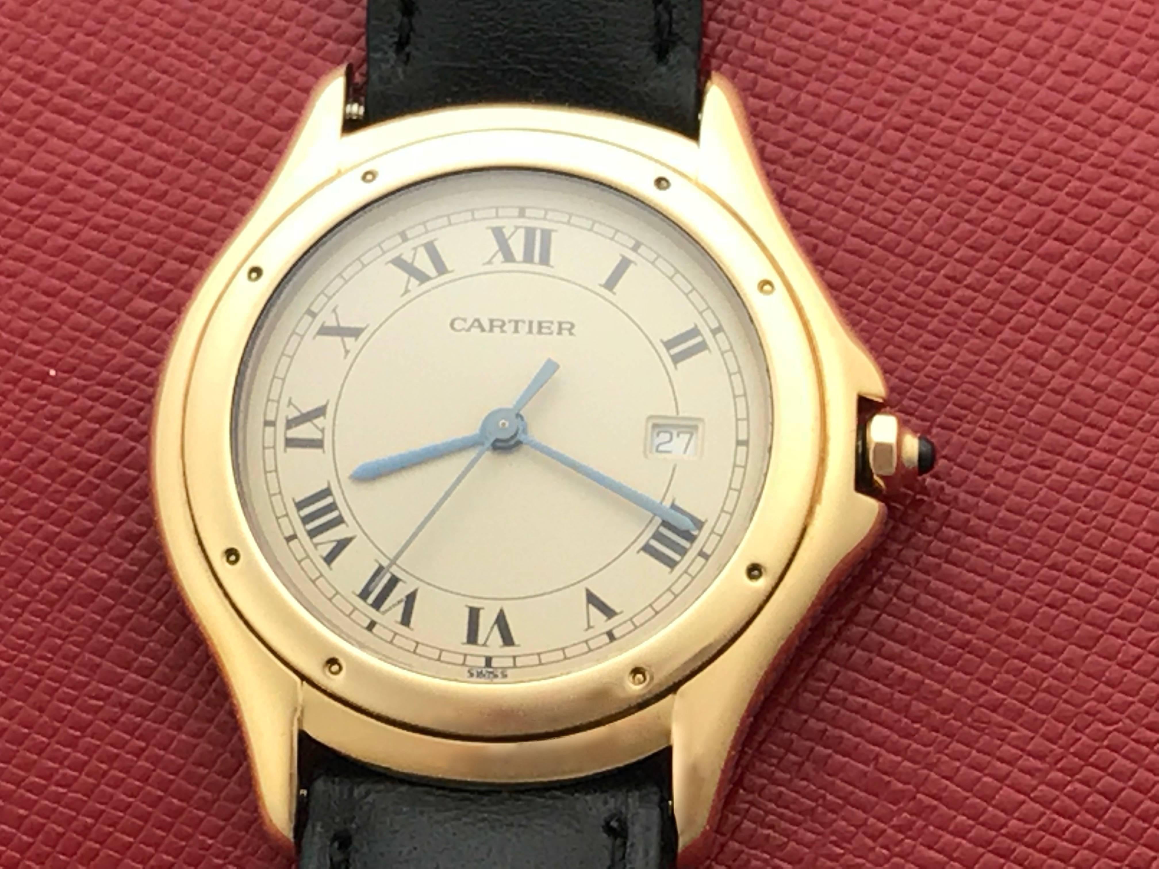 Cartier Cougar Ladies 18K Yellow Gold Quartz Wrist Watch.  Certified pre-owned and ready to ship.  Quartz movement with date.  18k Yellow Gold round style case with blue cabachon sapphire crown. (33mm)  Black leather strap with yellow gold filled