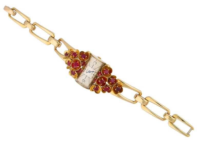 Ruby set watch by Cartier. An extremely rare watch by Cartier, set with sixteen round old cut rubies in claw settings of varying sizes with an approximate combined weight of 4.00 carats, four flanking the central face and the remaining twelve set
