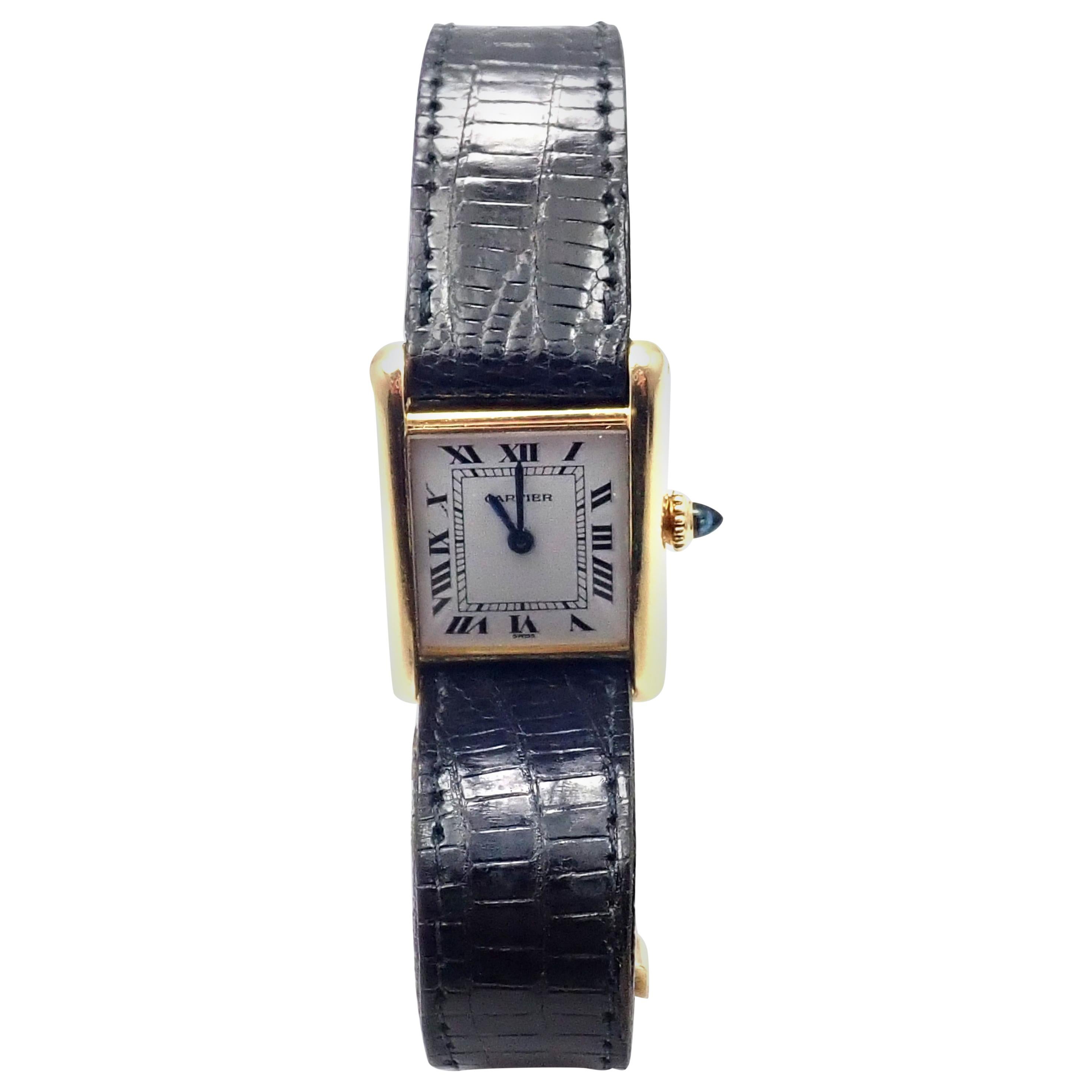 Lady's 18k yellow gold Cartier Tank wristwatch.
Details: 
Brand: Cartier
Case Material: 18k Yellow Gold
Dial Color: White
Movement: Manual Wind
Functions: Hours, Minutes
Crystal: Cartier mineral glass crystal
Case: 28mm x 21mm
Crown: Sapphire
Strap:
