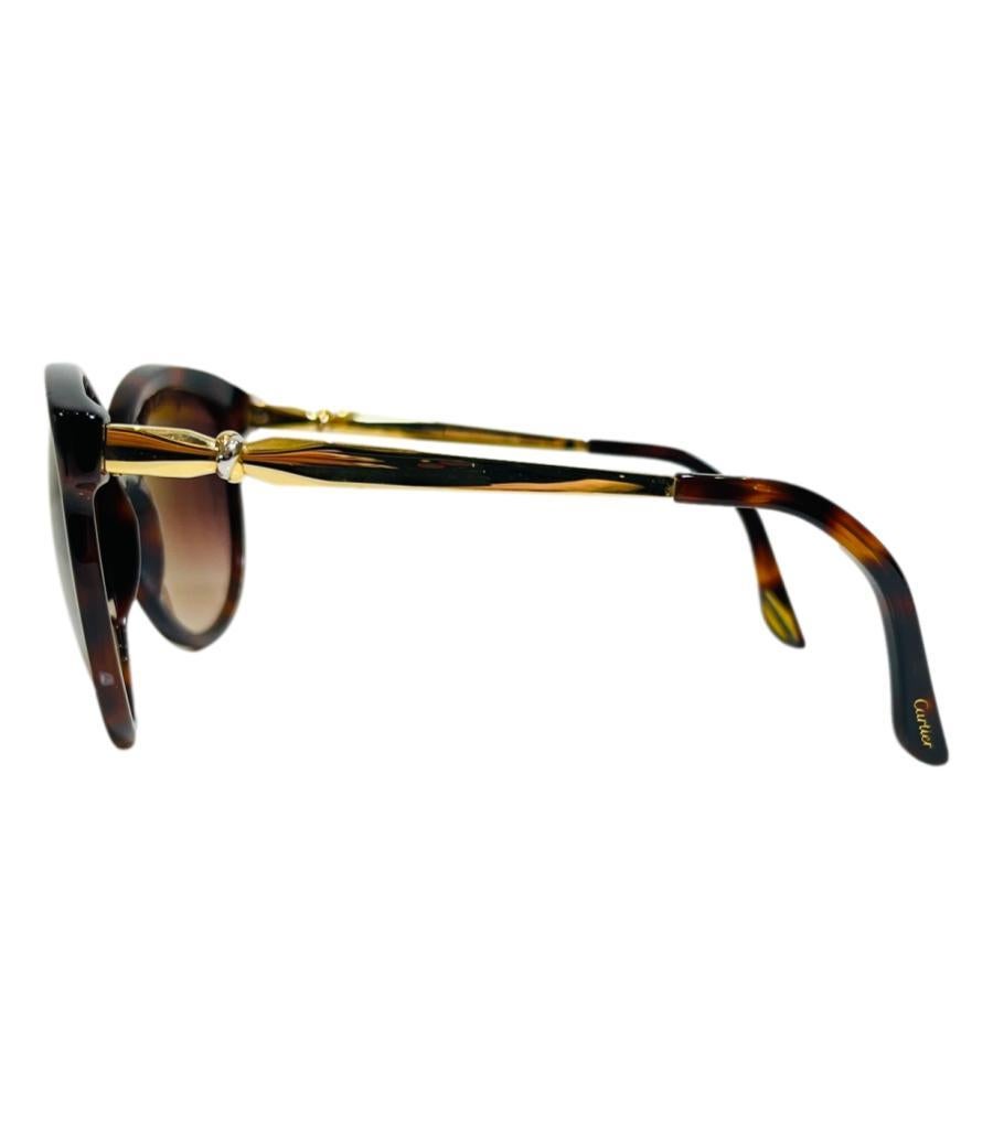 Cartier Lady Trinity-Sonnenbrille
Sonnenbrille mit braunem Schildpattgestell und polarisierten, getönten Gläsern.
Ausgestattet mit goldenen Metallarmen und einem dreifarbigen Goldring.
Größe - Einheitsgröße
Zustand - Sehr gut (Gebrauchsspuren an der