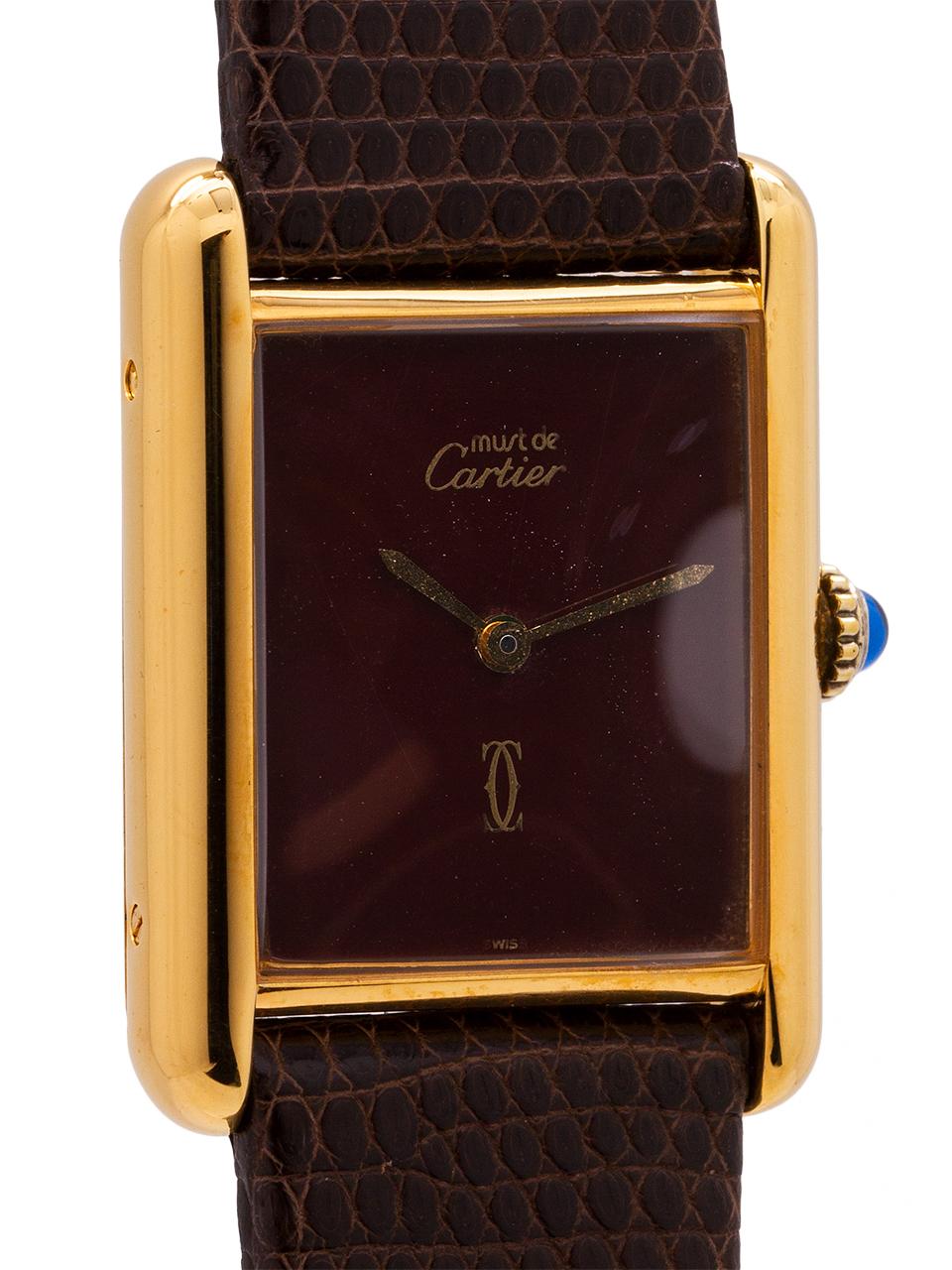 
Cartier lady’s vermeil Tank Louis circa 1980s. Featuring a 23 X 31mm case secured by 4 side screws. Featuring original burgundy color dial signed Must de Cartier and with Cartier double C logo, gilt hands, and blue cabochon sapphire crown. Powered