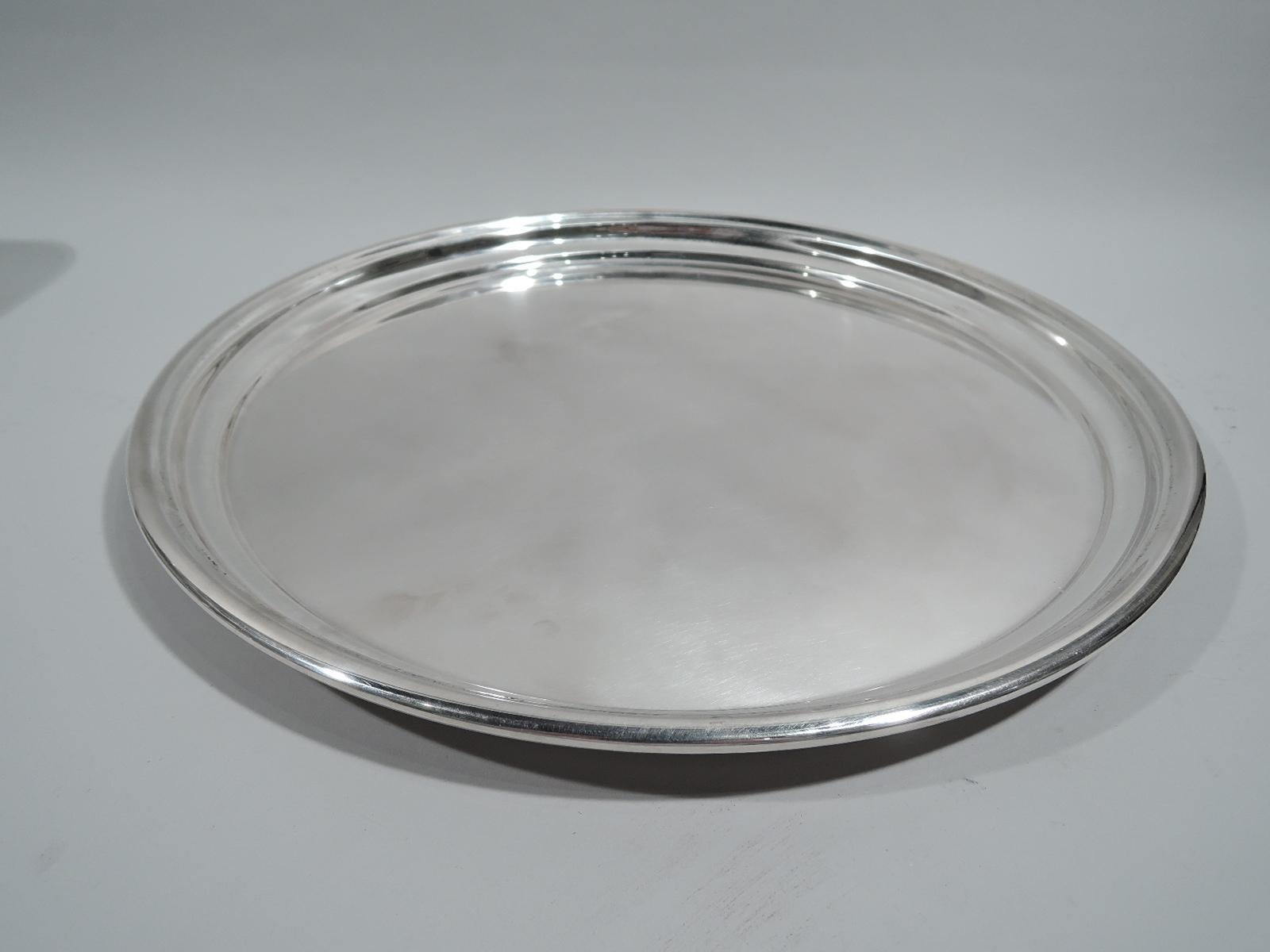 Large and Modern sterling silver tray, ca 1960. Retailed by Cartier in New York. Round with curved sides and molded rim. Perfectly portable with nice heft and balance. Fully marked including retailer’s stamp and no. 354P. Weight: 43.5 troy ounces.