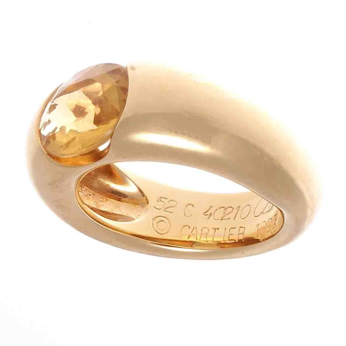 The elegance of Cartier shines through with this citrine and 18k yellow gold ring. Featuring a beautifully faceted golden colored citrine that is invisibly set into the wide tapered band. Signed Cartier and numbered and stamped with French