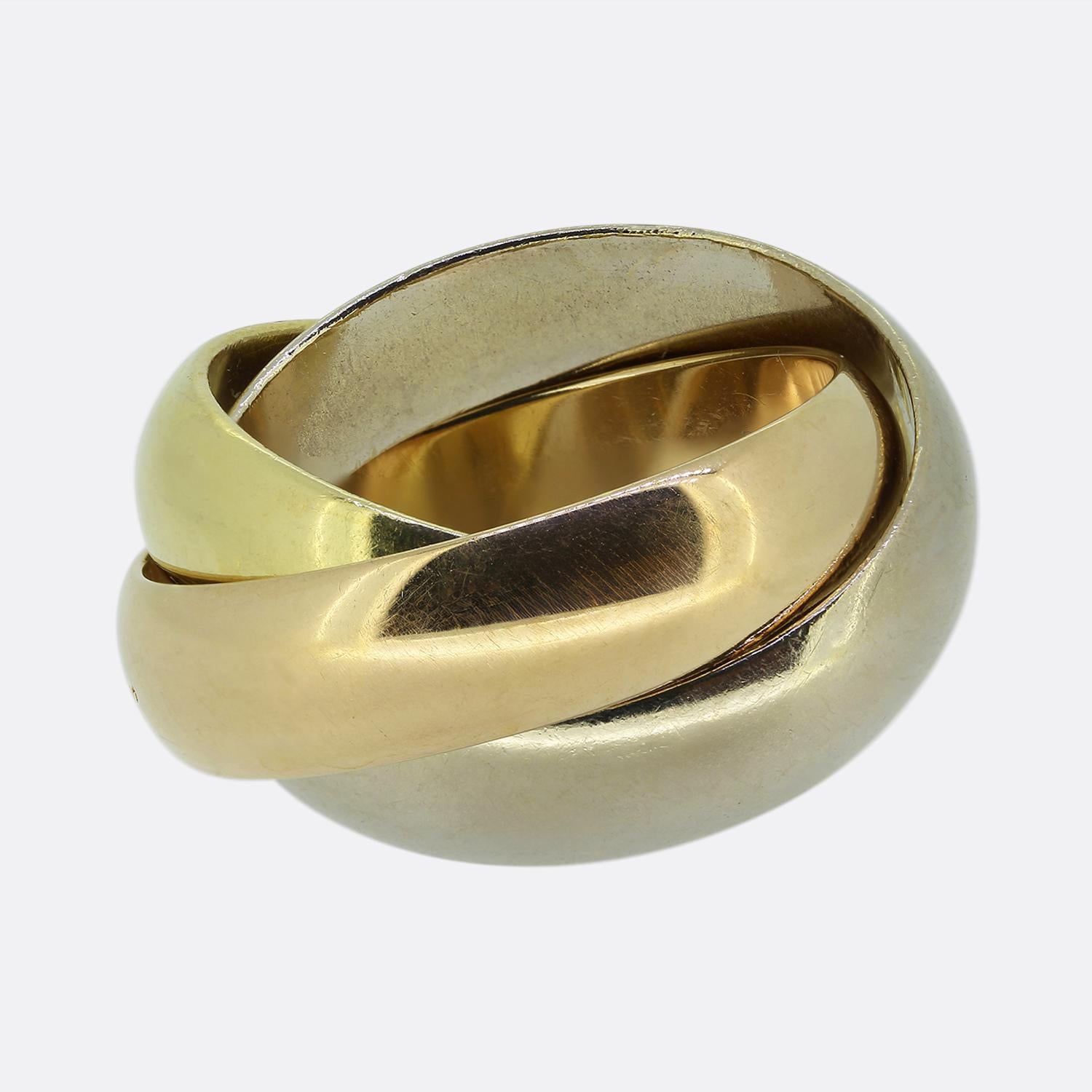 Nous avons ici une pièce classique de la maison de joaillerie de luxe de renommée mondiale Cartier. Cette bague comporte trois anneaux entrelacés en or 18 ct : jaune, blanc et rose, le rose étant gravé du mot 
