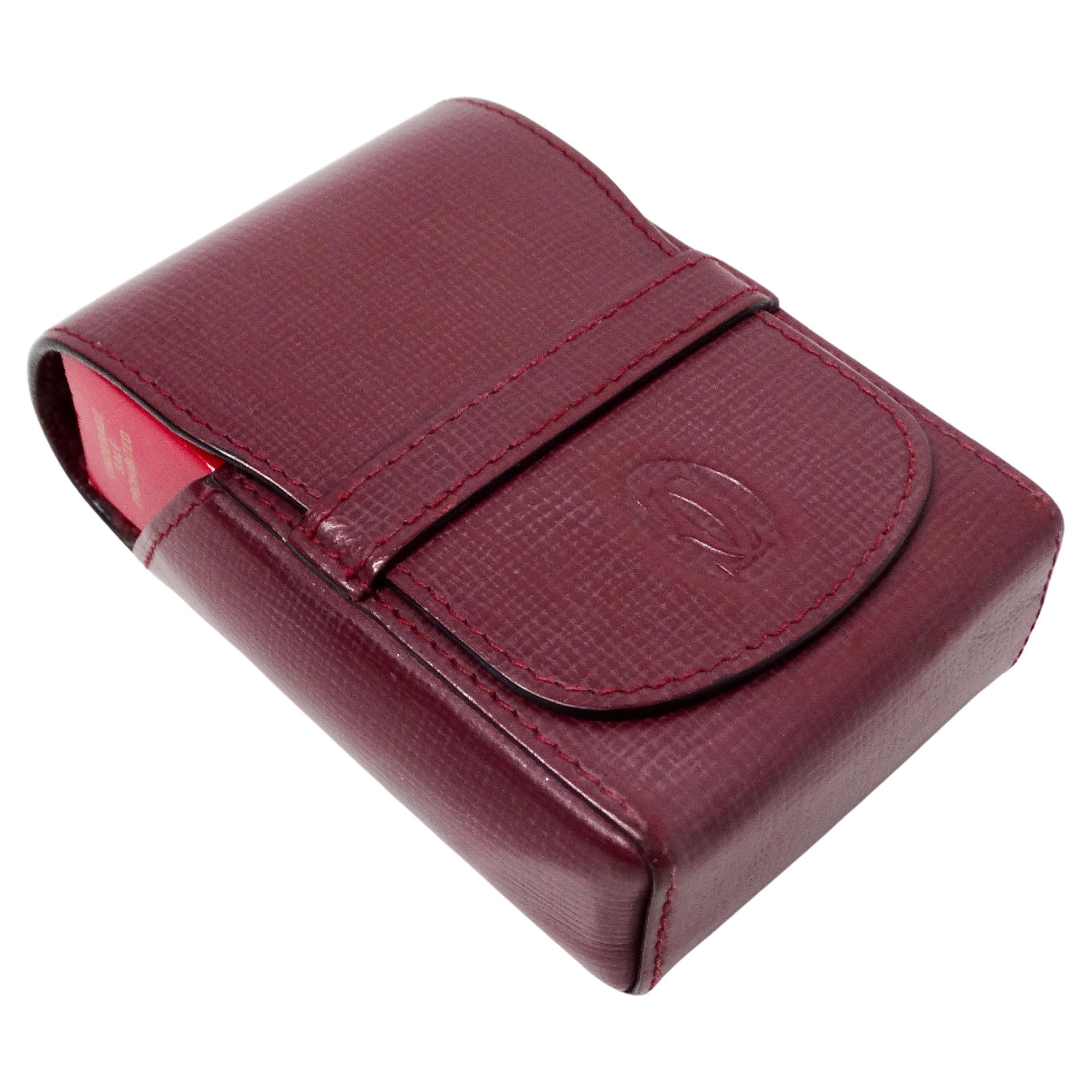 The Cartier Le Must de Cartier Burgundy Leather Pouch from the circa 1980s is a quintessential accessory that exudes timeless elegance and sophisticated craftsmanship. Crafted from rich burgundy leather, this embossed pouch features the iconic