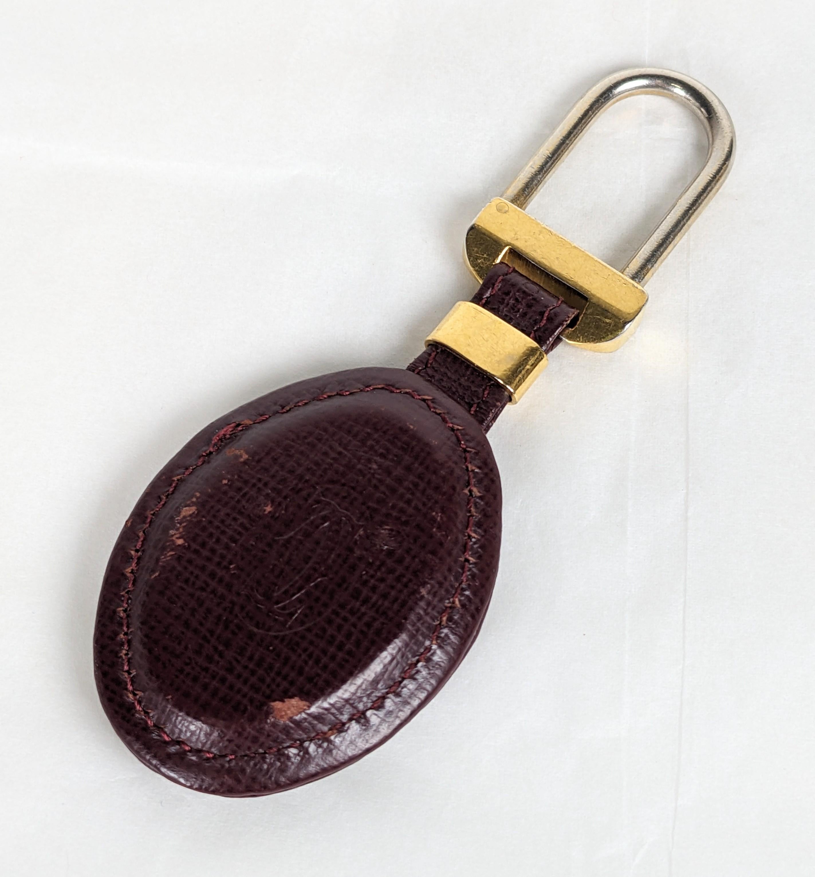 Cartier Leather Fob Key Holder from the 1980's. Leather fob embossed with house logo in signature Cartier tones. Some areas of wear which can be reconditioned.  Signed Cartier on gilt metal findings. 4