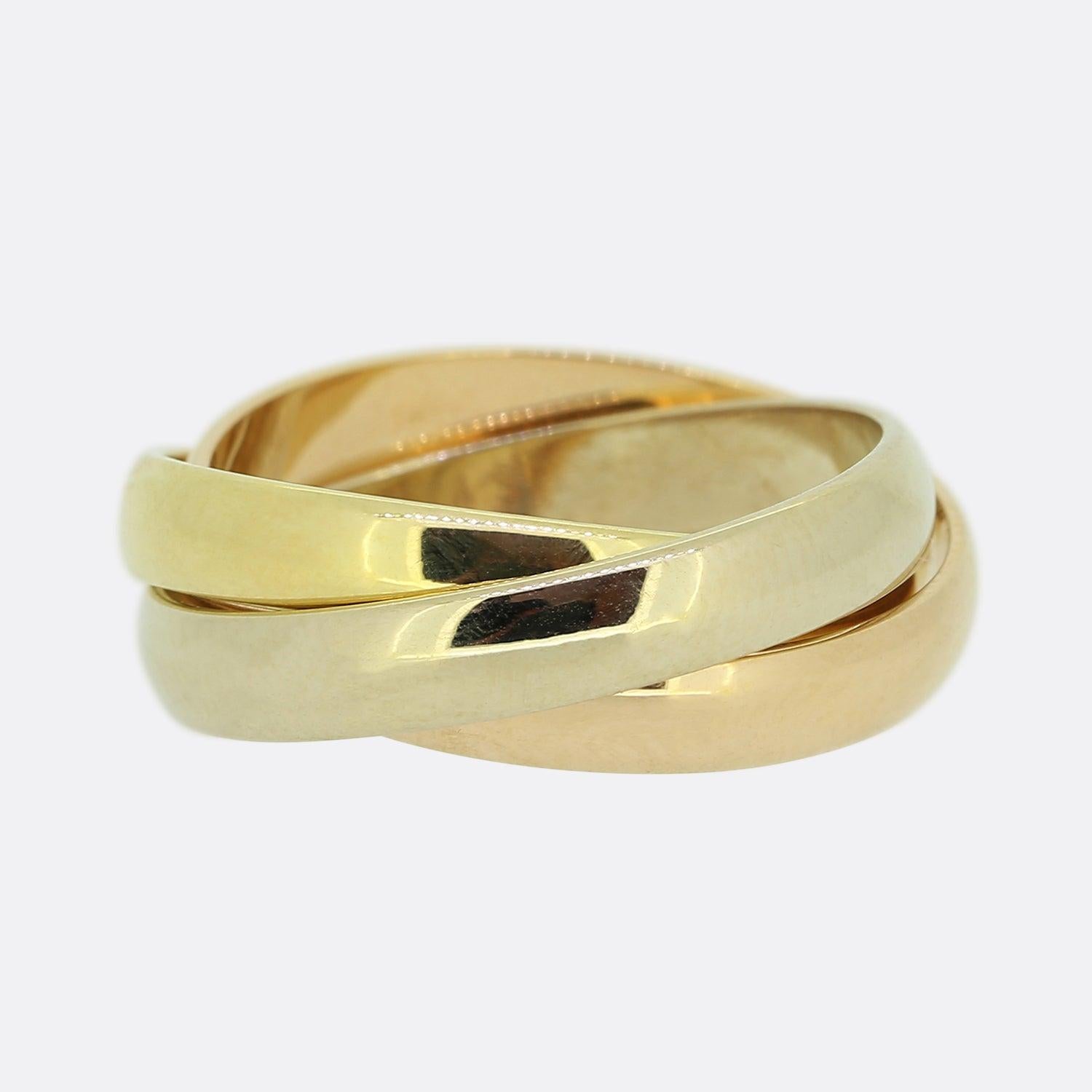 Here we have an 18ct gold trinity ring from the world renowned luxury jewellery house of Cartier. The ring features three interwinding bands of yellow, white and rose gold; the rose of which has been engraved with the words 'Les Must de Cartier'. 