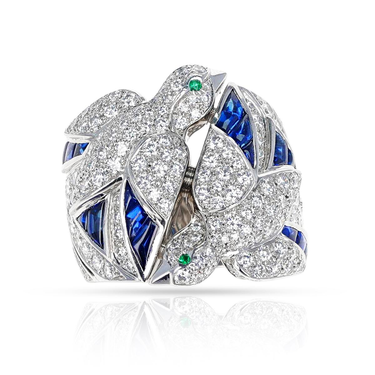 A rare Cartier Les Oiseaux Libérés Diamond, Emerald and Sapphire Ring. The ring size is US 5.50. The total weight is 18.42 grams. The ring is crafted in 18 Karat Gold. 