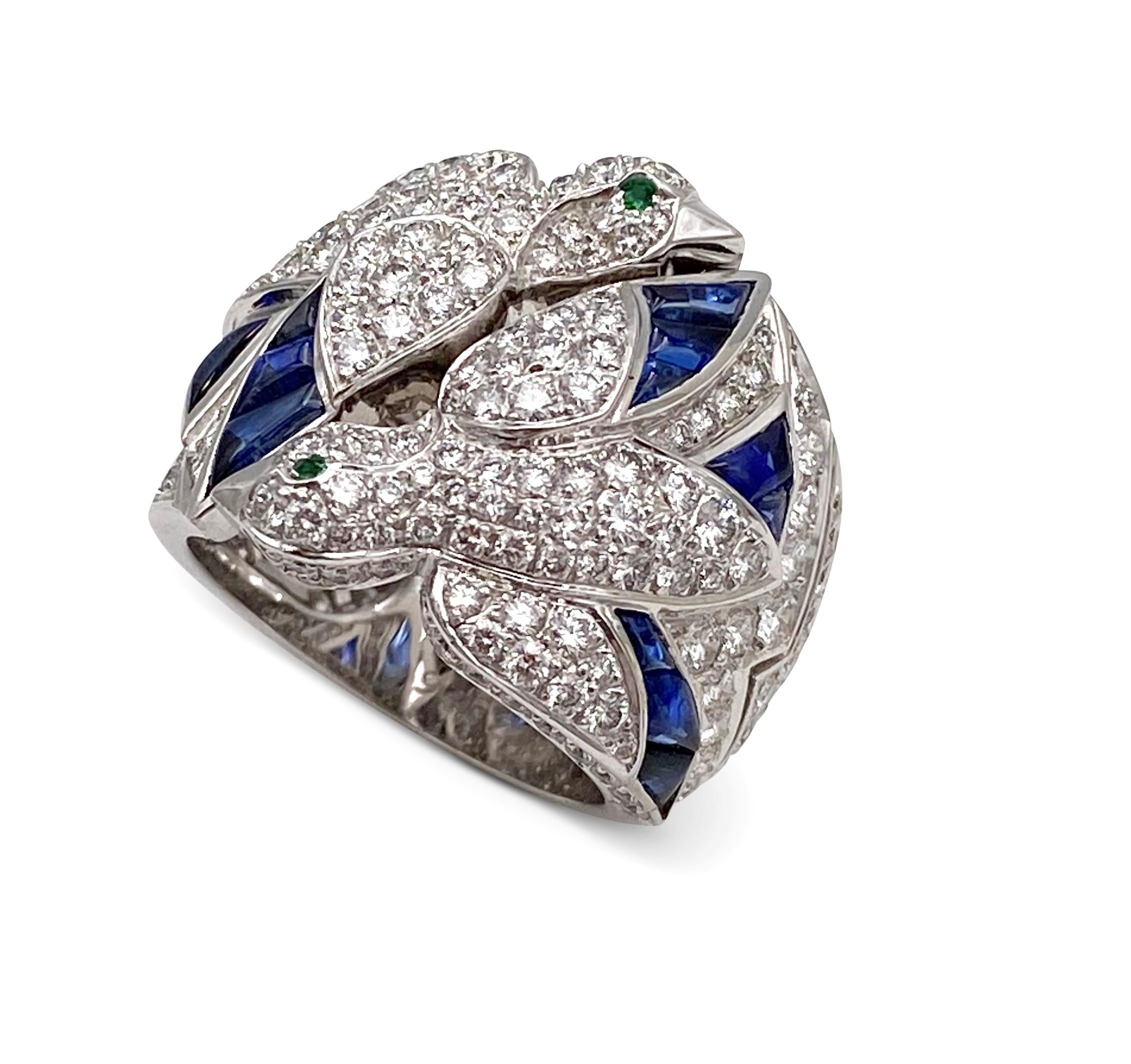 Rare Cartier 'les Oiseaux Liberes' ring centers on two doves taking flight adorned with an estimated 5.50 carats of pave set round brilliant cut diamonds (E-F color, VS clarity) and carved cabochon sapphires. The dove eyes are bezel set with emerald