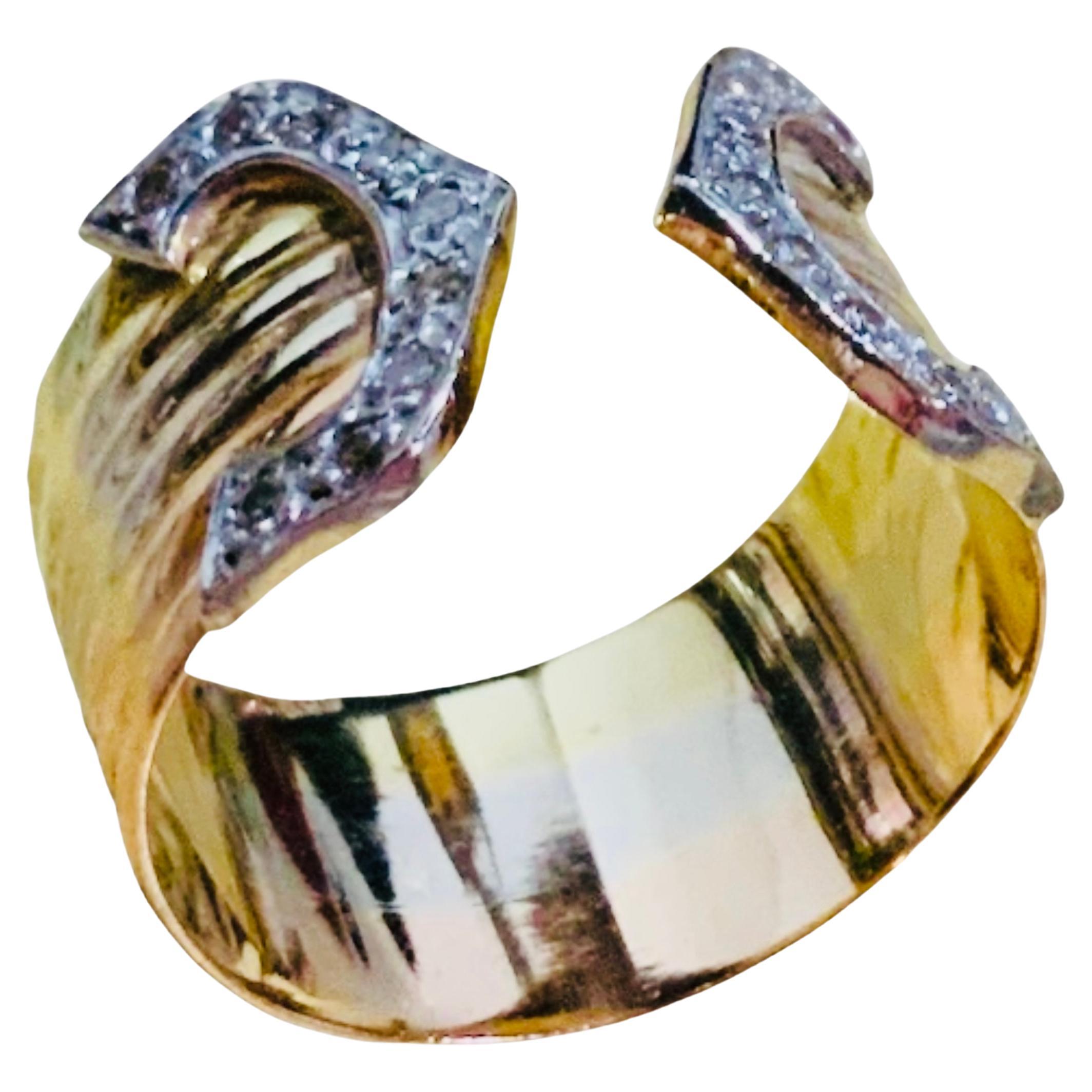 This is an Equestrian style 14K gold and diamonds horseshoes cigar band ring. The ring is mounted in 14 K tricolor gold and contains an eighteen brilliant diamonds weighing approximately 0.20 carats. They are mounted in pave setting. The ring’s