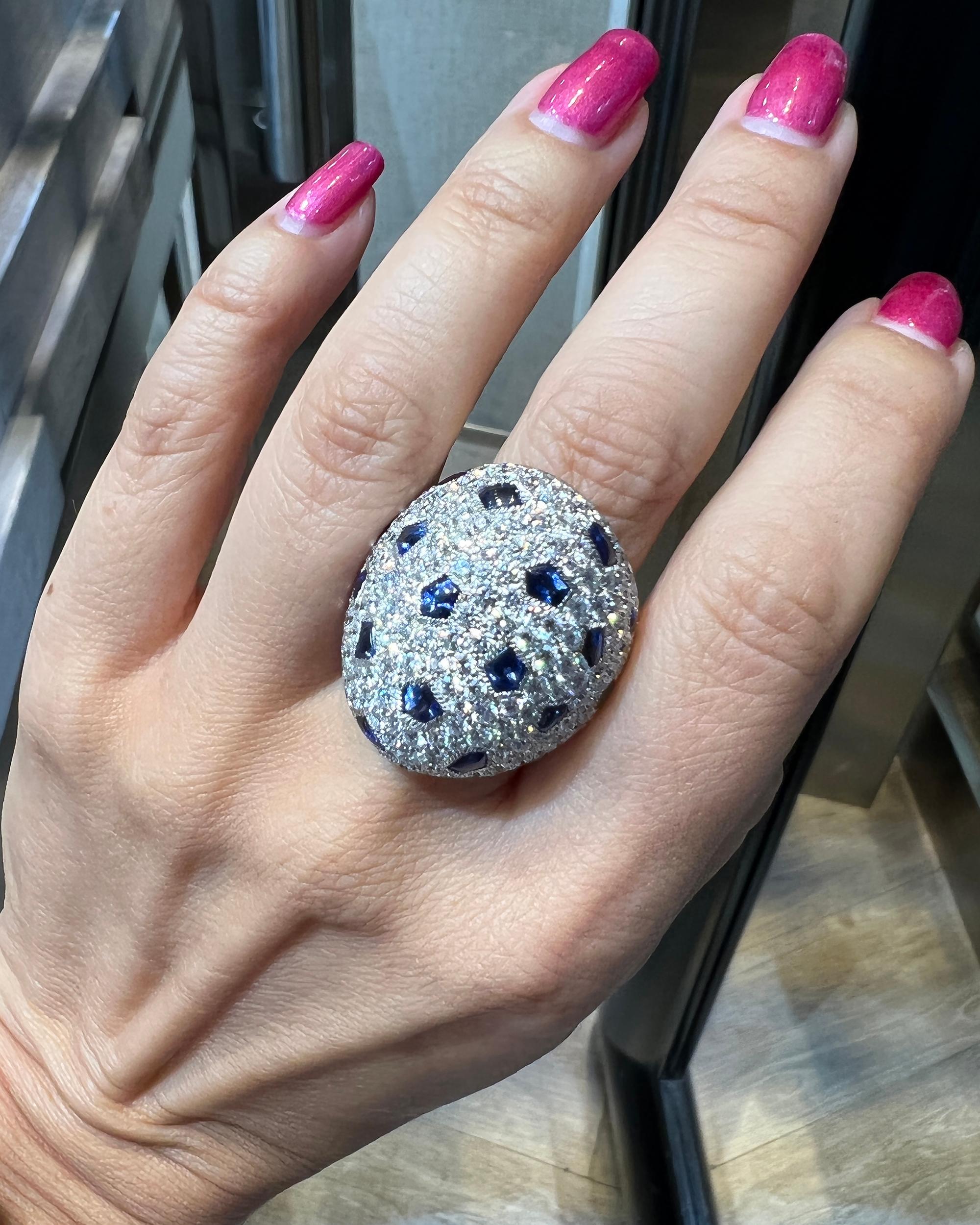 A stunning cocktail ring, showcasing round diamonds weighing a total of approximately 4.5 carats and buff top blue sapphires. 
The diamonds are G-H color, VS clarity.
Metal is 18k white gold; gross weight is 25 grams.
Signed Cartier, numbered.
US