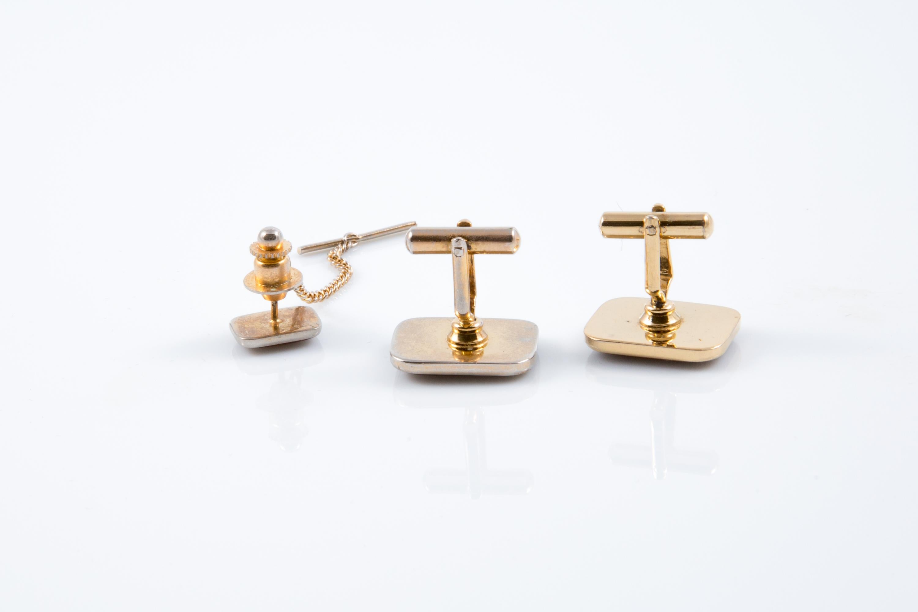 Juego de gemelos y pasador de corbata con logotipo de Cartier Burdeos con forma rectangular, logotipo central dorado en el centro y exterior dorado. Vienen en un par + un accesorio para la corbata. 
En buen estado vintage. Fabricado en