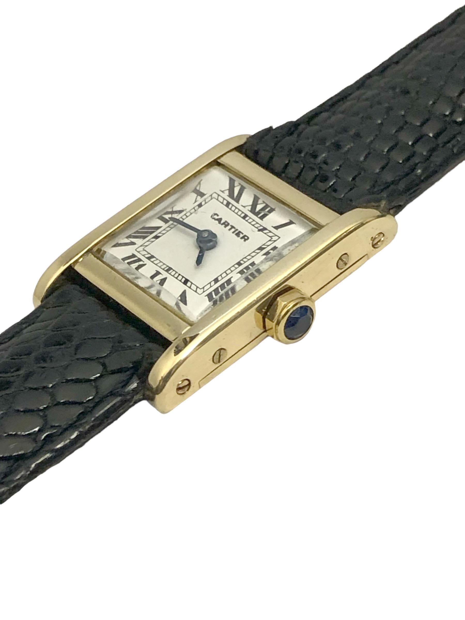 CIRCA 1960er Cartier London Damen Tank Armbanduhr, 18 x 17 M.M. 18k Gelbgold London gestempelt 2 Stück Gehäuse, Saphir gesetzt Krone, 17 Juwelen Jaeger-LeCoultre Mechanische, Handaufzug Bewegung. Weißes Zifferblatt mit schwarzen römischen Ziffern.