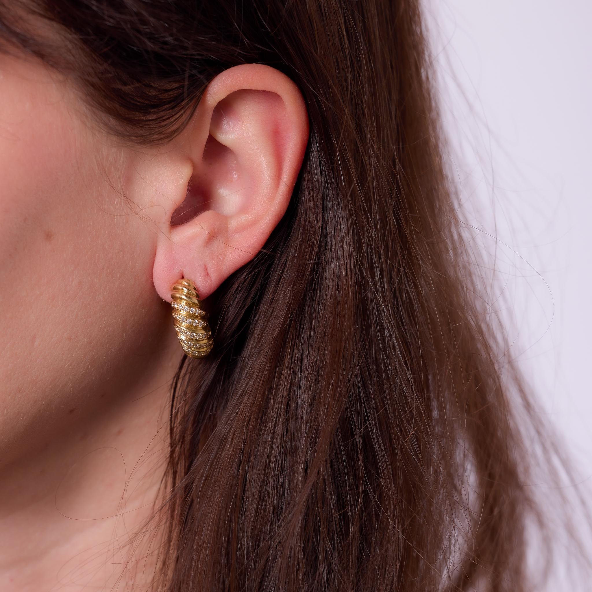 Crafted in the 1990s, these vintage Cartier London earrings are set in 18k yellow gold and feature 70 round brilliant cut diamonds totaling approximately .70 carats, graded F color and VS clarity. Their soft curves and radiant sparkle reflect