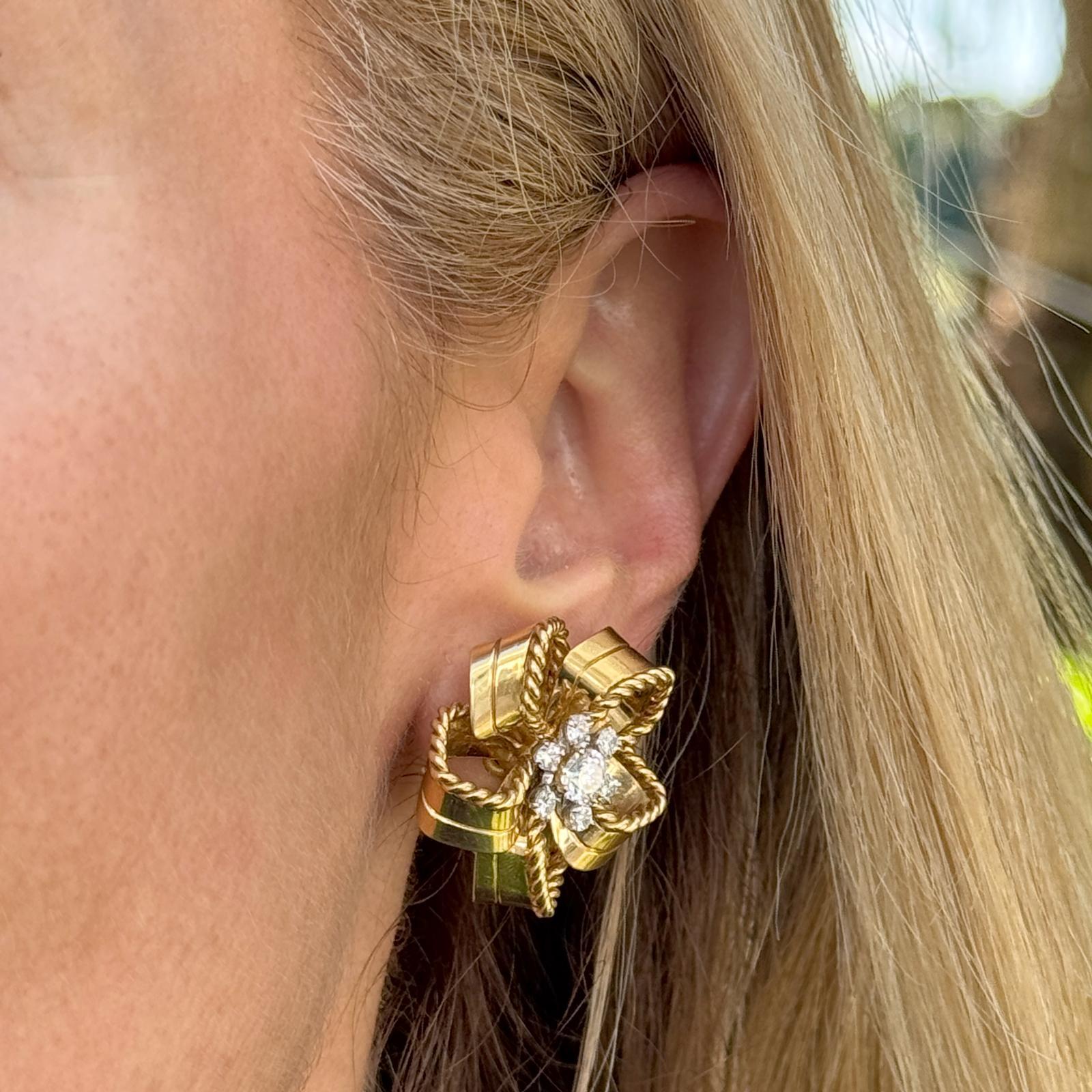 Diese einzigartigen und seltenen Ohrclips von Cartier London aus der Mitte des 20. Jahrhunderts zeigen ein elegantes Bandknoten-Motiv, das in reichem 18-karätigem Gelbgold gefertigt wurde. Im Mittelpunkt jedes Ohrrings steht ein einzelner runder